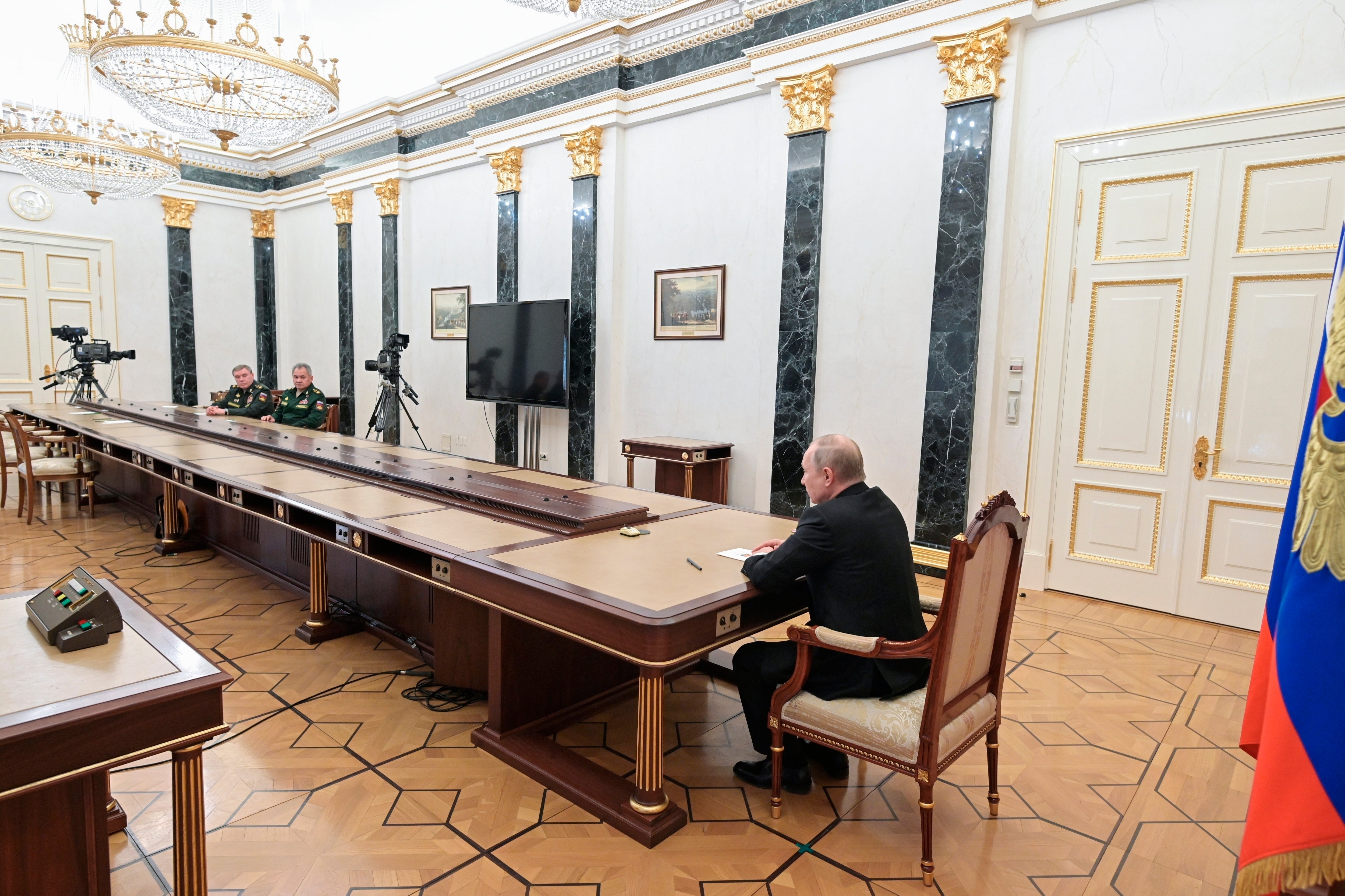 Russian President Vladimir Putin, right, speaks to Russian Defense Minister Sergei Shoigu, second left, and Head of the General Staff of the Armed Forces of Russia and First Deputy Defense Minister Valery Gerasimov, left, during their meeting in Moscow, Russia, Sunday, Feb. 27, 2022.
