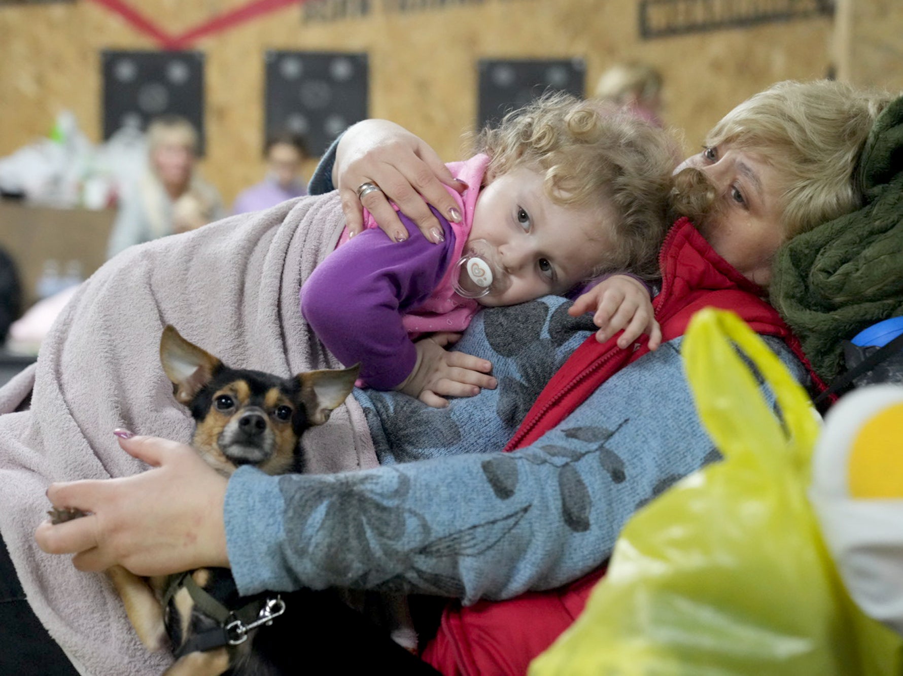 A woman holds a child and a dog in a shelter inside a building in Mariupol, Ukraine, Sunday 27 February 2022
