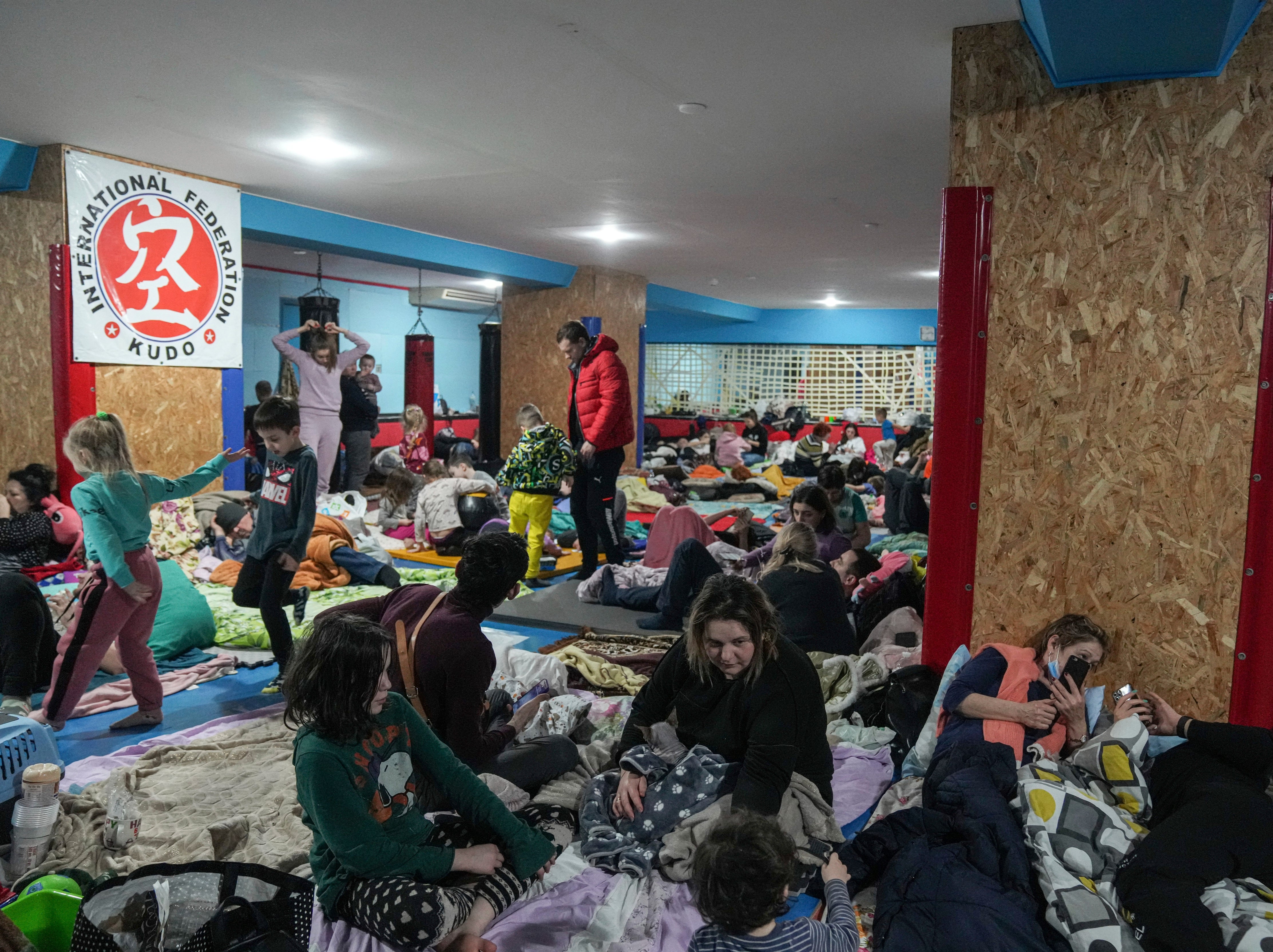 People sit on the floor in an improvised bomb shelter at sports centre, which can accommodate up to 2,000 people, in Mariupol, Ukraine