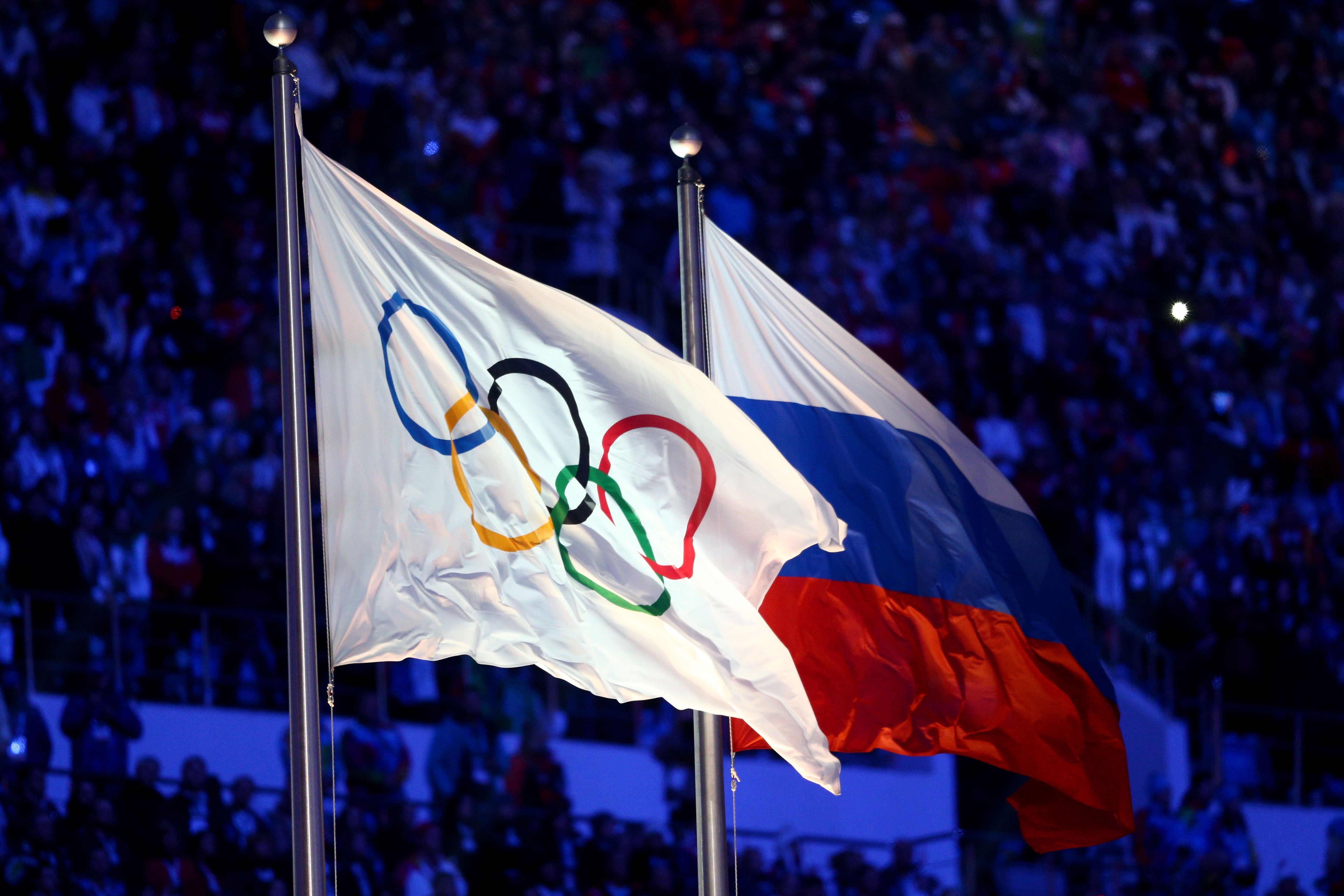 The Olympic flag and Russian flag are raised at the 2014 Sochi Winter Olympics