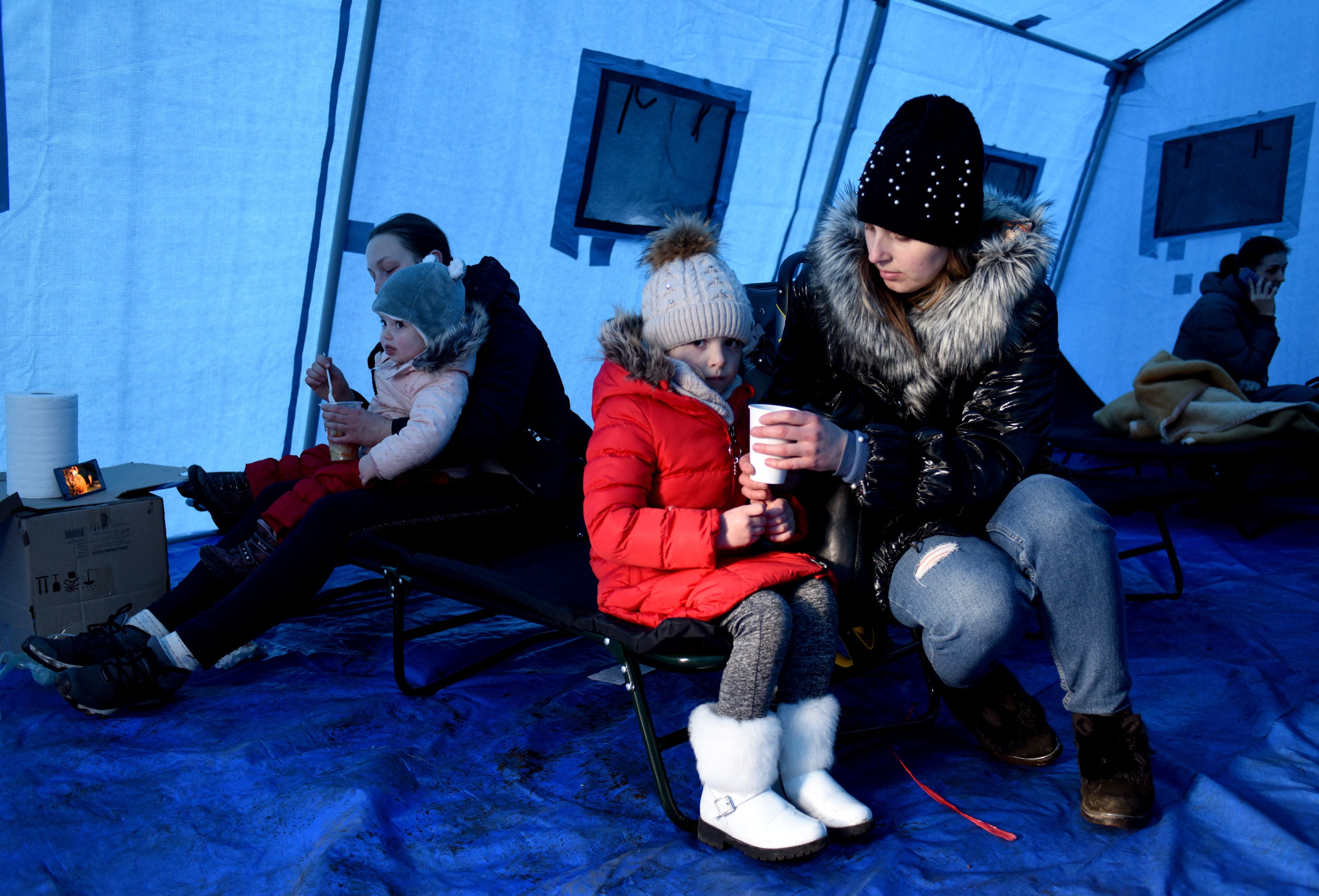 Women feed children inside a tent set near Lviv main railway station in western Ukraine, 28 February 2022