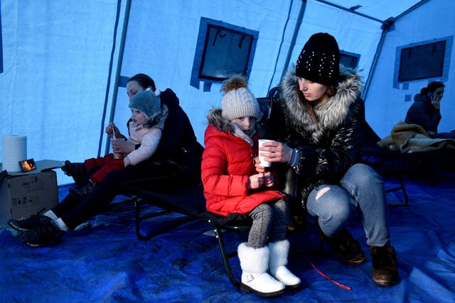 <p>Women feed children inside a tent set near Lviv main railway station in western Ukraine, 28 February 2022</p>