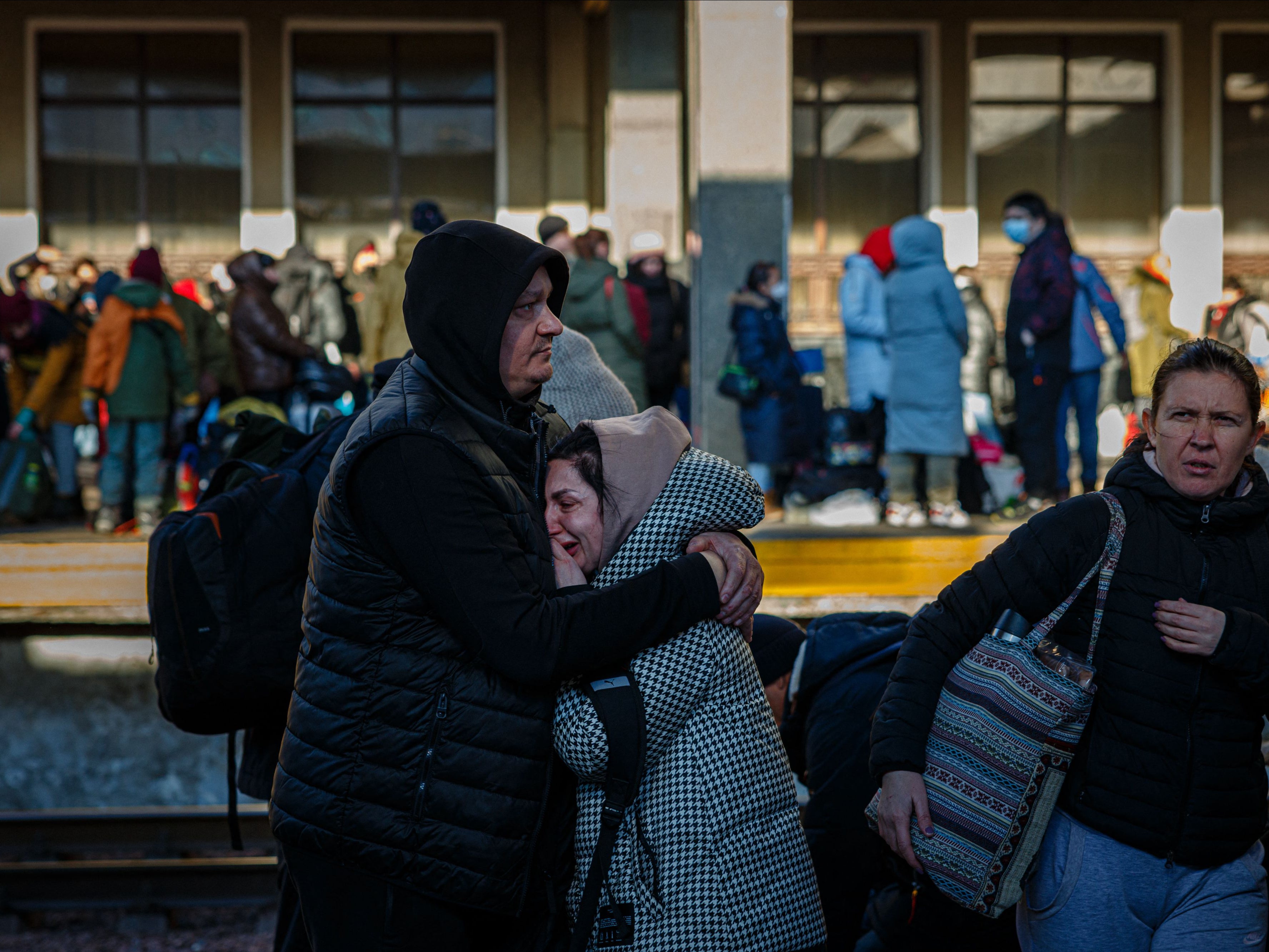 A man hugs his wife before she boards an evacuation train at Kyiv central train station