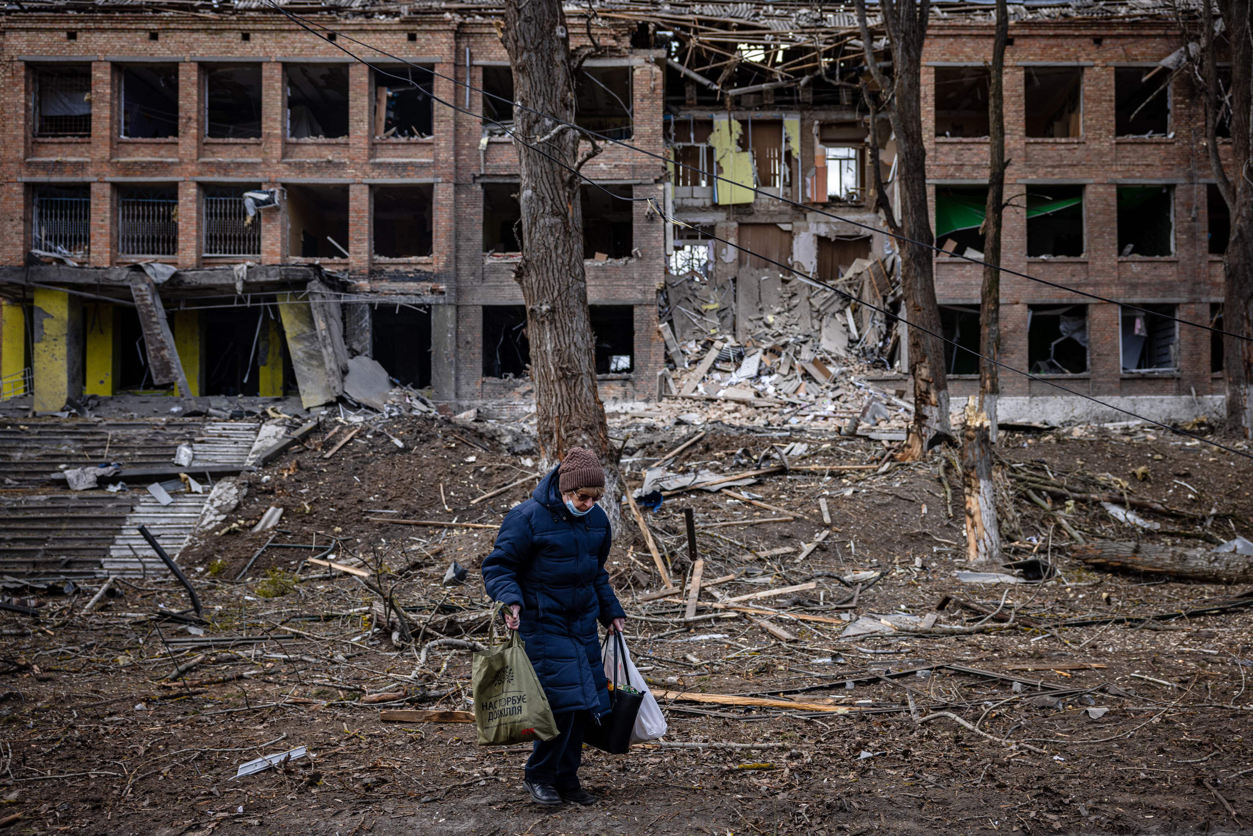 A woman in front of a building destroyed by a Russian missile attack, near Kyiv