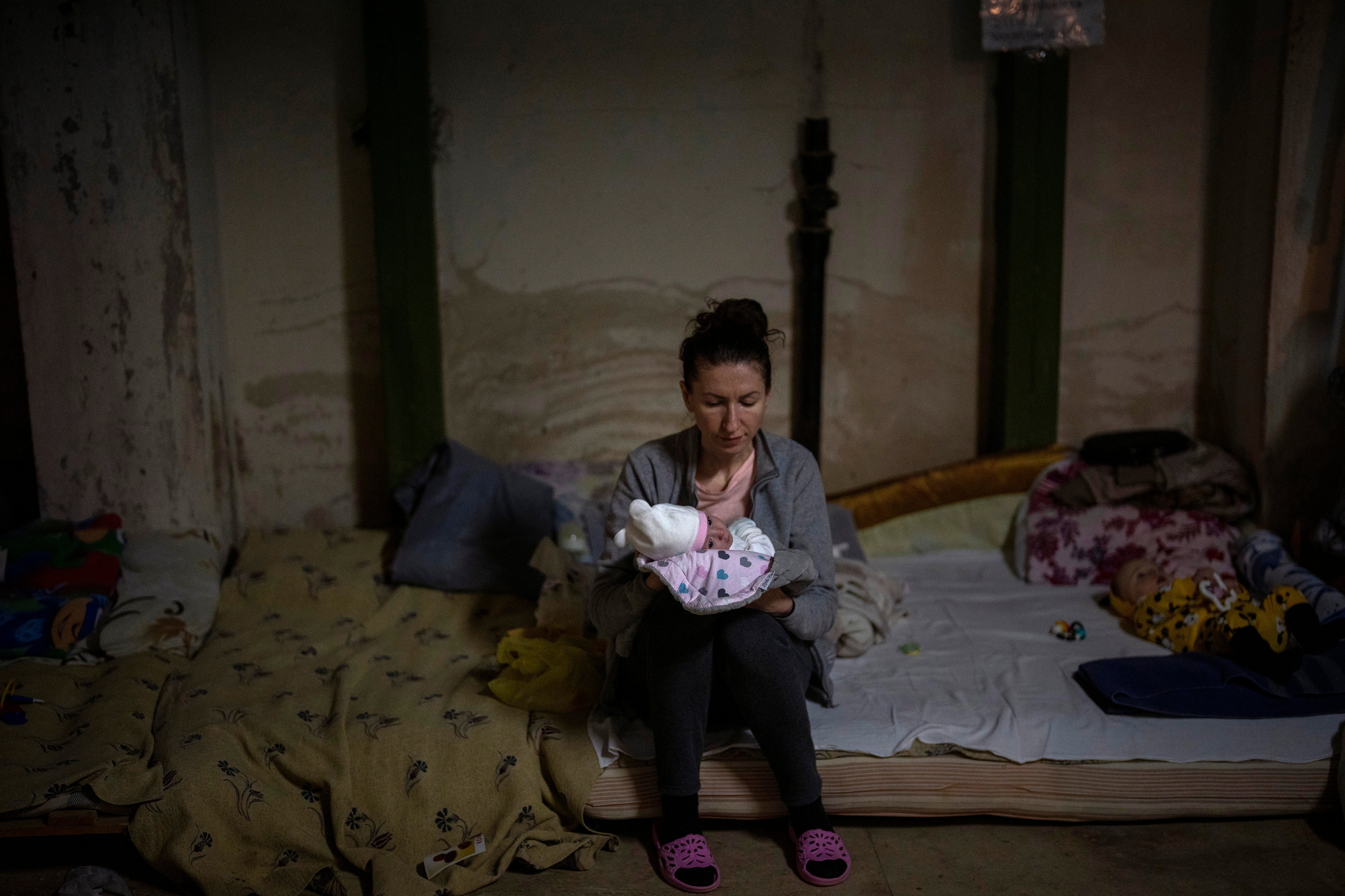 A woman holds her newborn baby inside a basement used as a bomb shelter at the Okhmadet children's hospital in central Kyiv