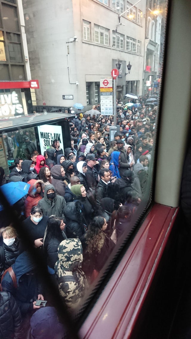 Crowds outside a bus at Liverpool Street station