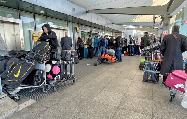 <p>Passengers queue at the Arrivals entrance of Heathrow Airport T5</p>