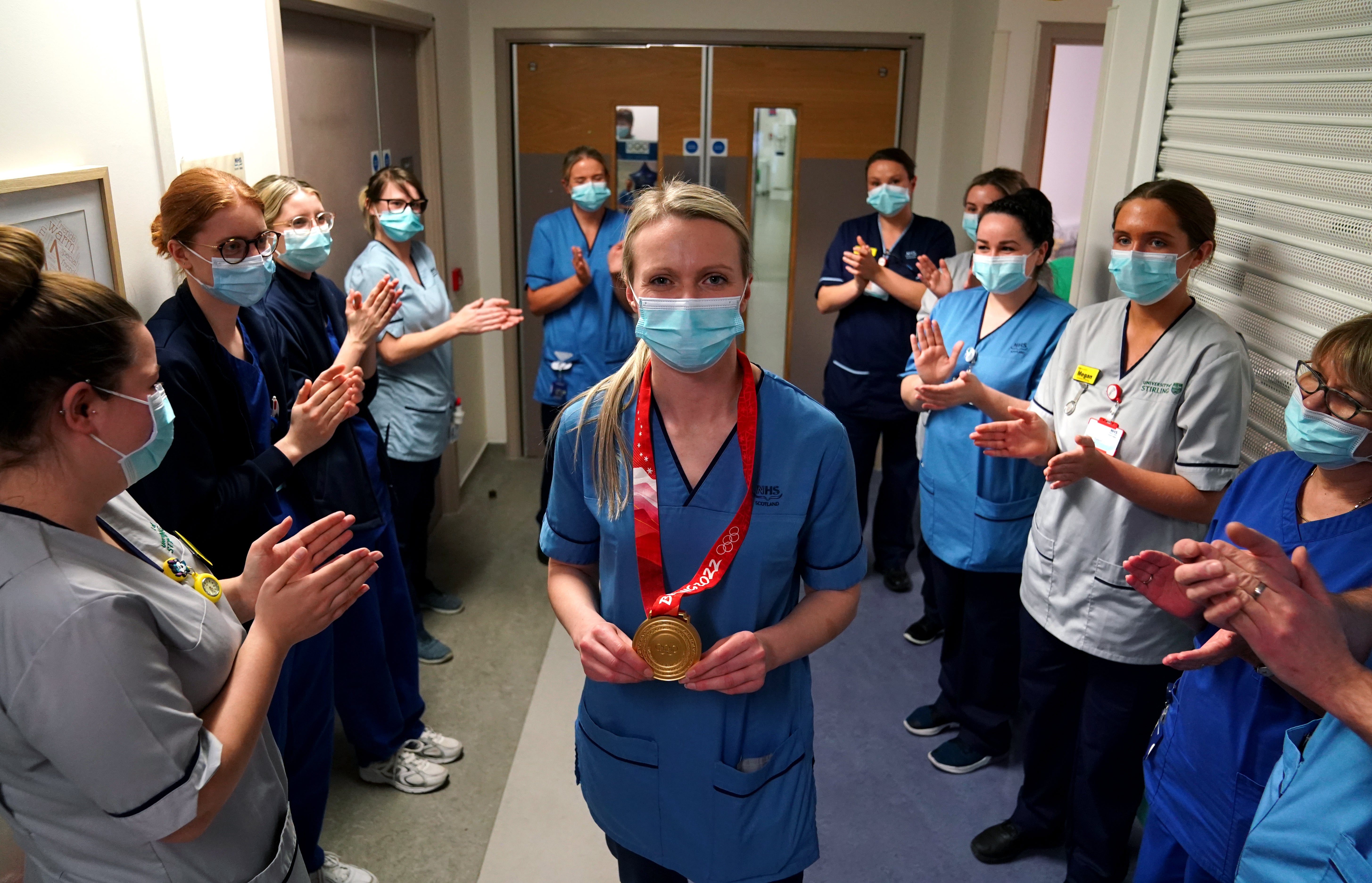 Olympic gold medal winning curler Vicky Wright is clapped onto the ward by colleagues (Andrew Milligan/PA)