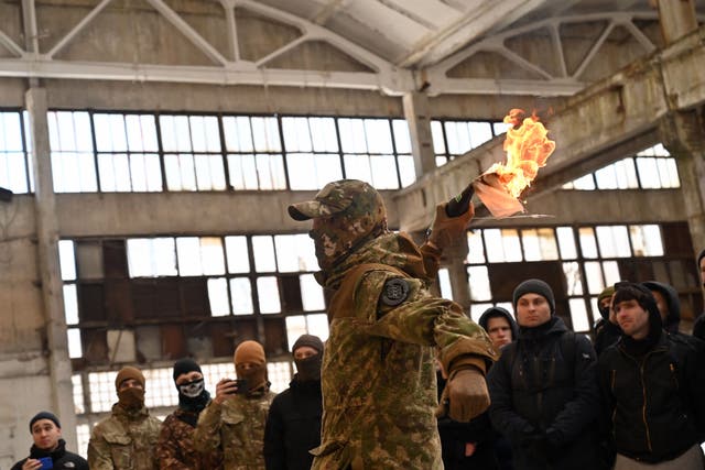 <p>A military instructor teaches civilians to use Molotov cocktails during a training session at an abandoned factory in Kyiv </p>