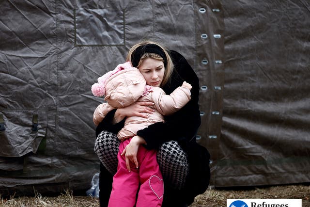 <p>A woman fleeing the Russian invasion of Ukraine hugs a child at a temporary camp in Przemysl, Poland</p>