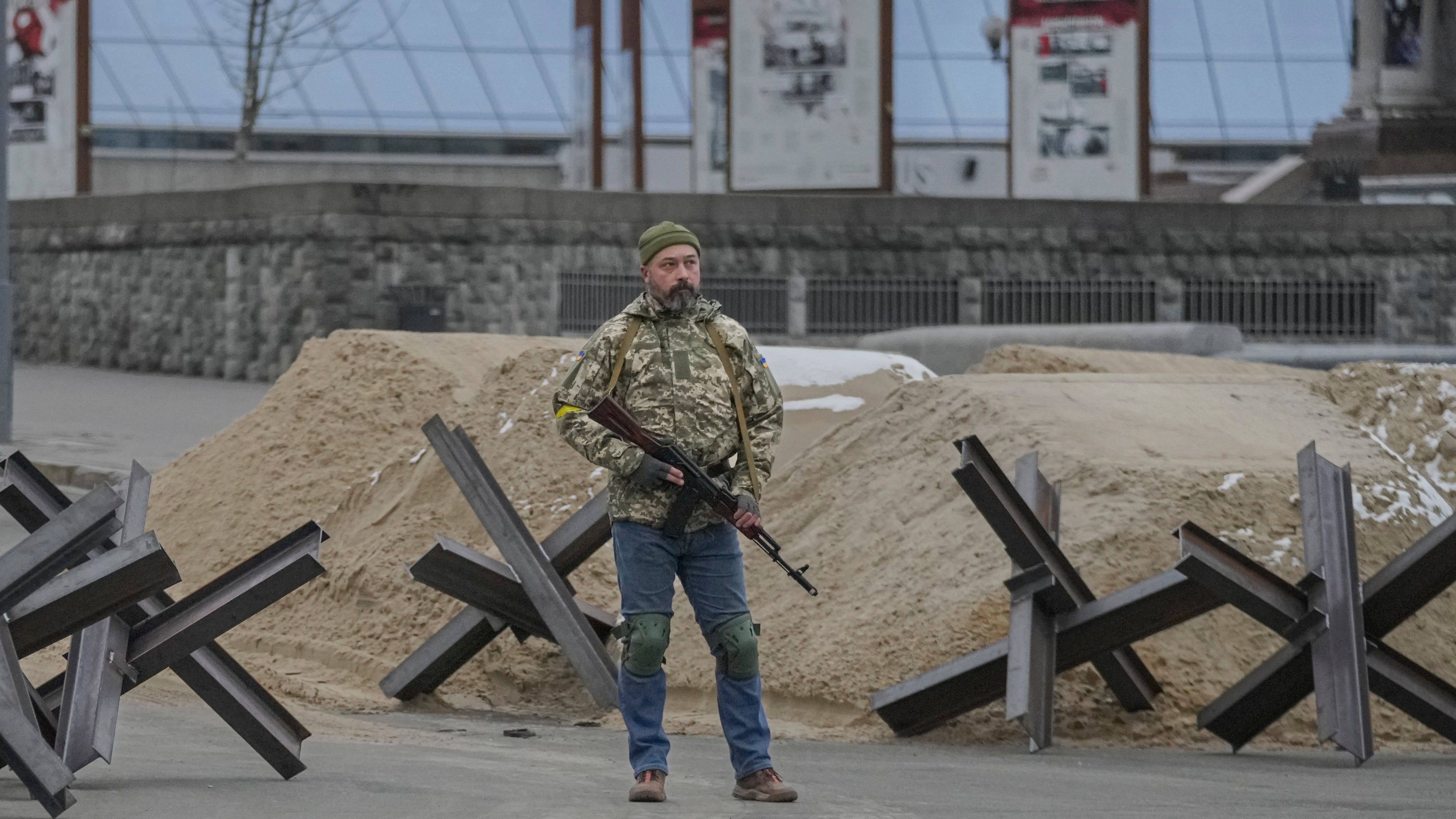 An armed man stands near a barricade during an air raid alarm in Maidan Square, in Kyiv (AP)
