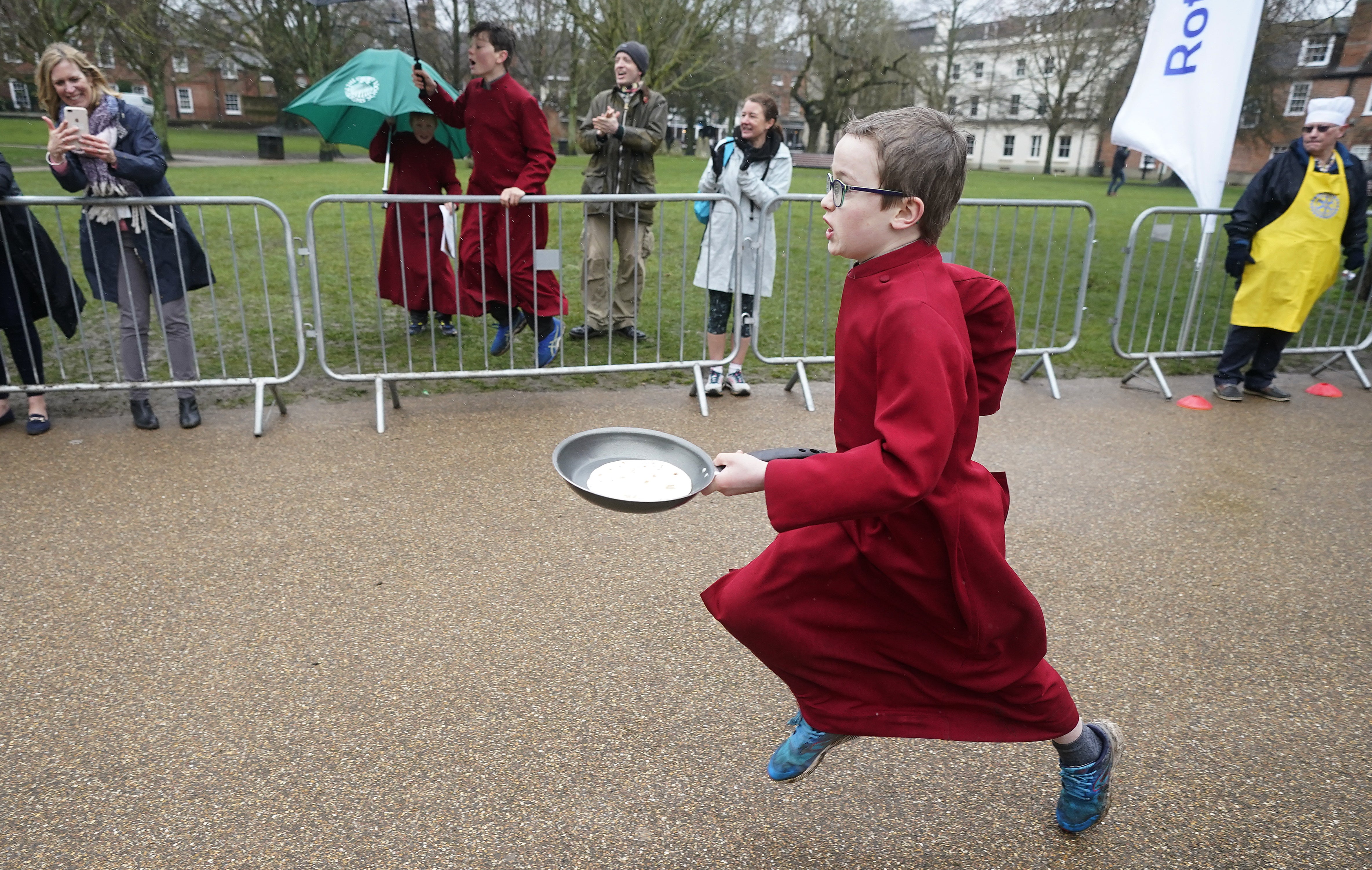 A boy chorister of Winchester Cathedral takes part in the Shrove Tuesday pancake race at Winchester Cathedral (Andrew Matthews/PA)