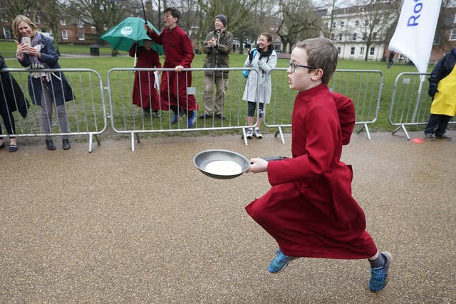 A boy chorister of Winchester Cathedral takes part in the Shrove Tuesday pancake race at Winchester Cathedral (Andrew Matthews/PA)