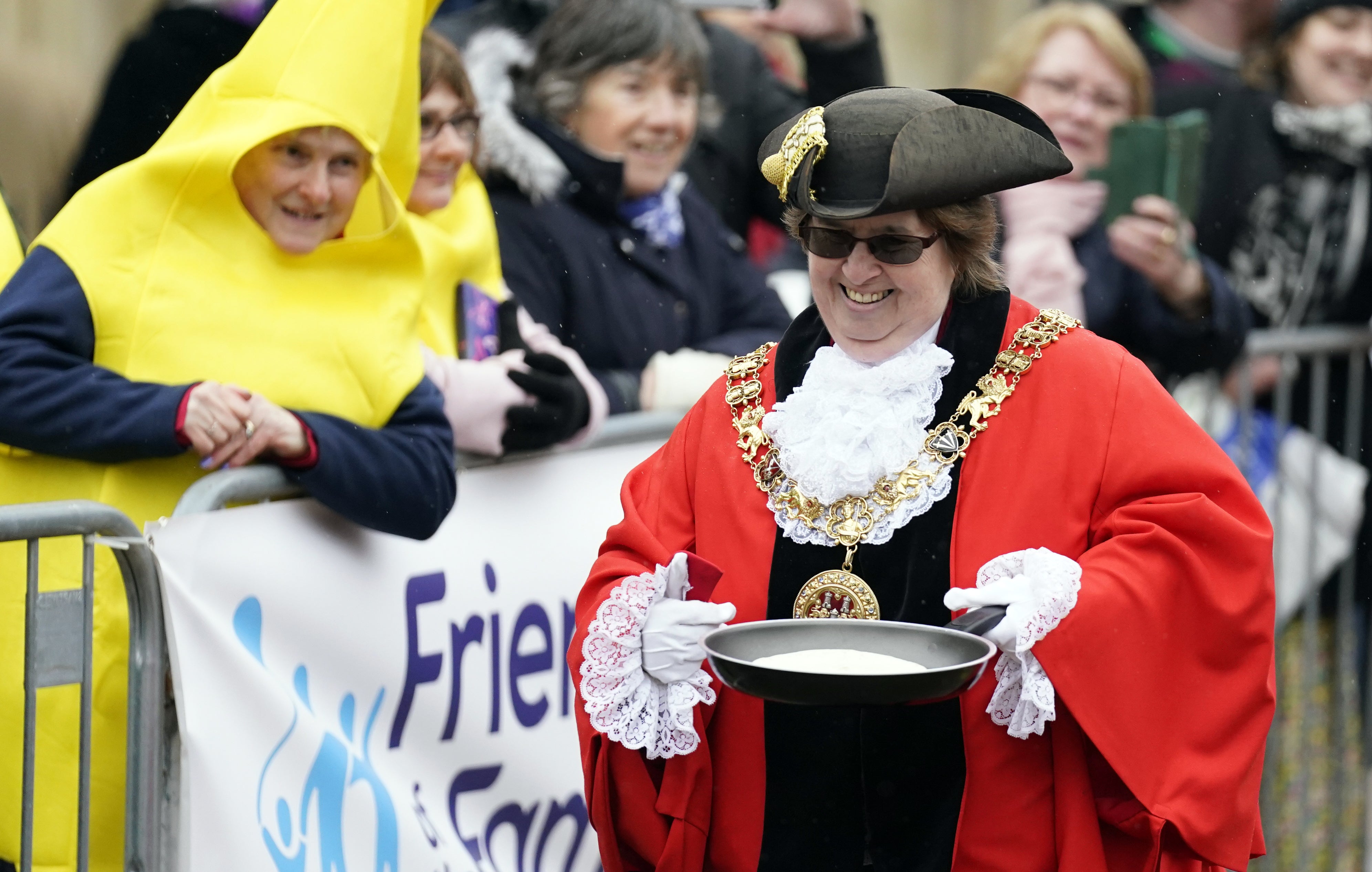 The mayor of Winchester, councillor Vivian Achwal, takes part in the Shrove Tuesday pancake race at Winchester Cathedral (Andrew Matthews/PA)