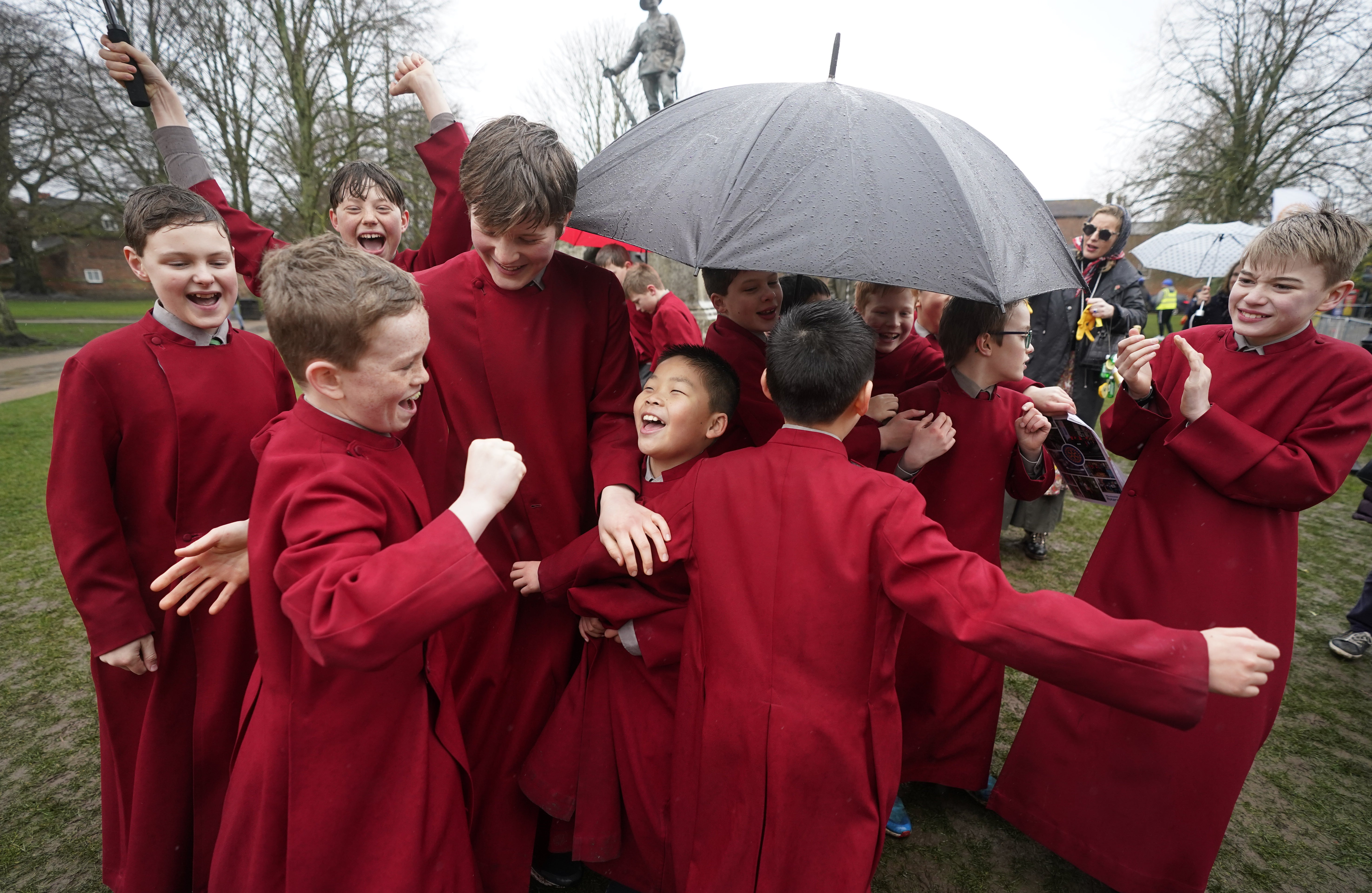 Choristers celebrate after one of their teams won the pancake race (Andrew Matthews/PA)
