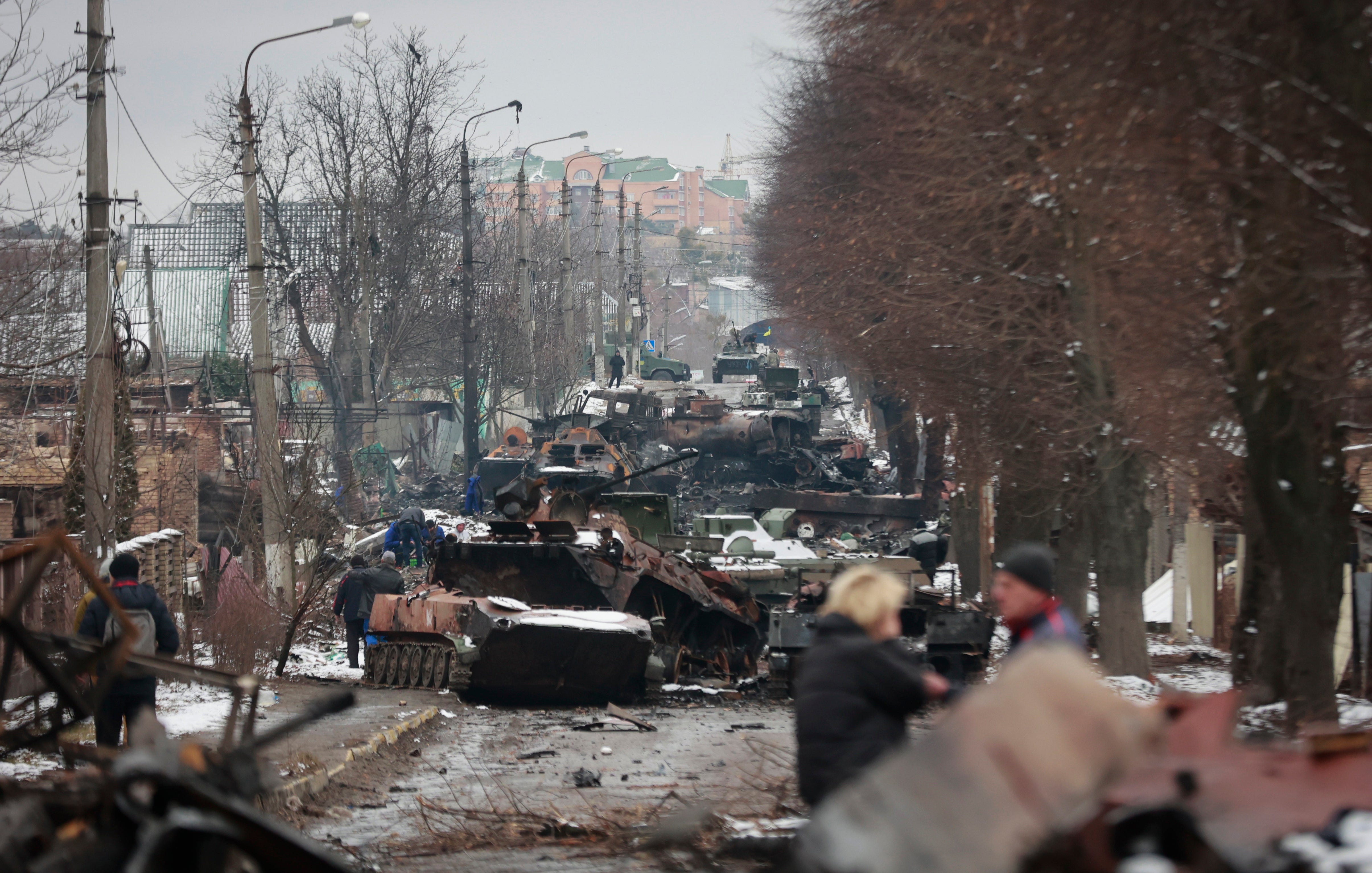 People look at the gutted remains of Russian military vehicles on a road in the town of Bucha, close to Ukraine’s capital Kyiv, on 1 March 2022