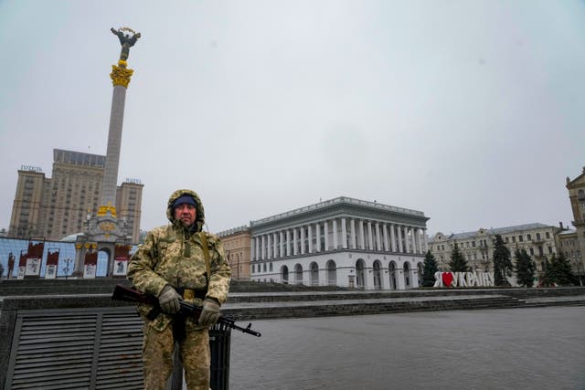An armed man stands at the Independent Square in the centre of Kyiv, Ukraine (AP)