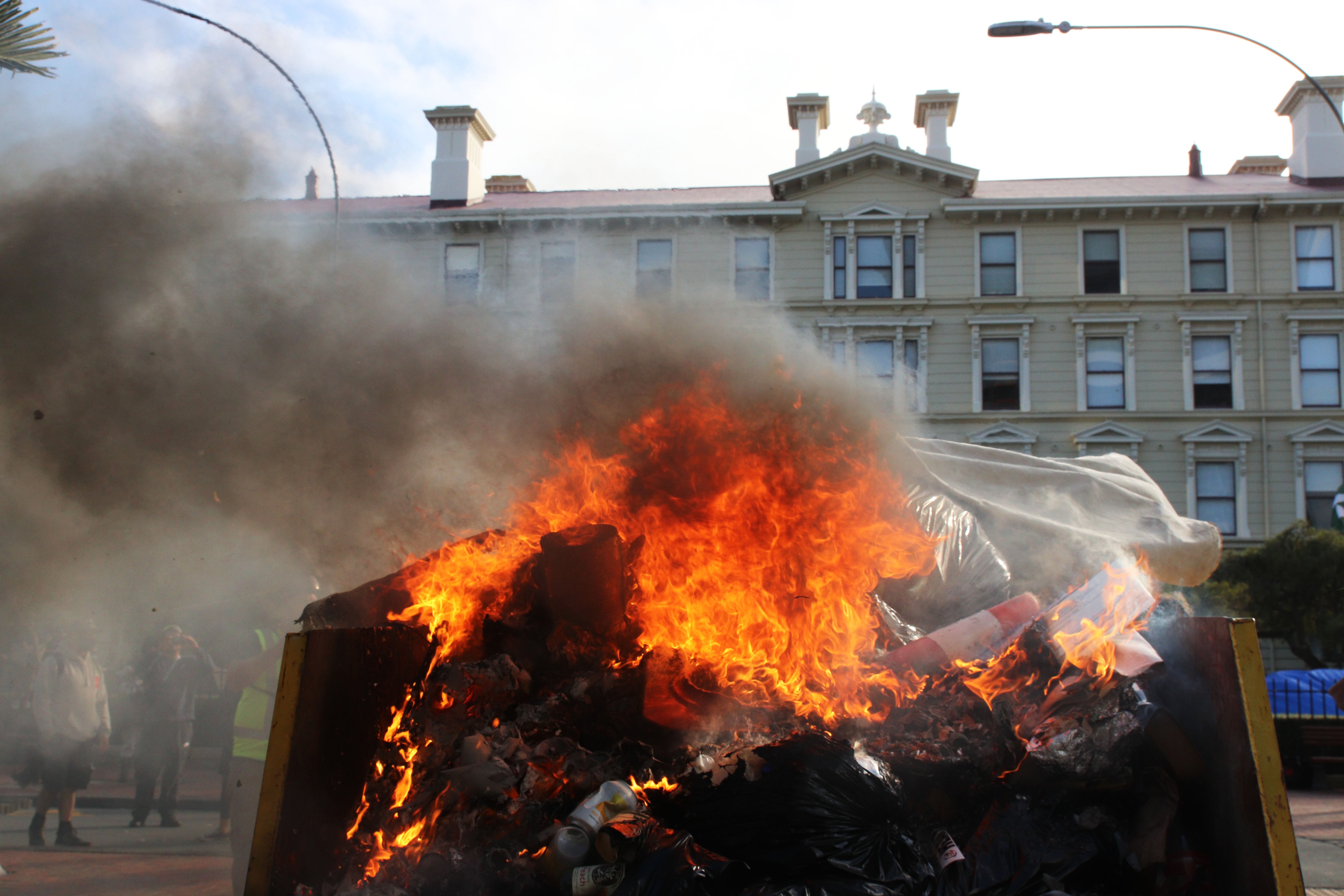 A fire burns in a rubbish skip on Bunny Street near Parliament and Victoria University after riot police moved to break up the occupation of Parliament’s grounds and surrounding streets