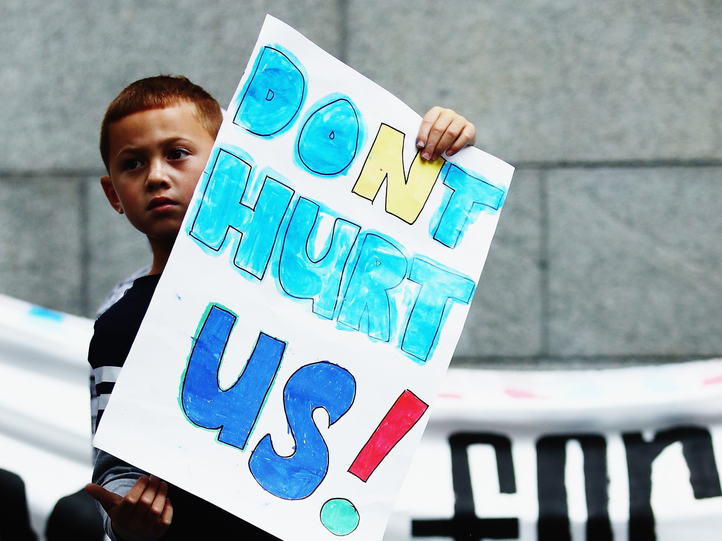 A young boy holds up a sign during a march down Queen Street to bring awareness to child abuse and family violence on 22 May 2016 in Auckland, New Zealand