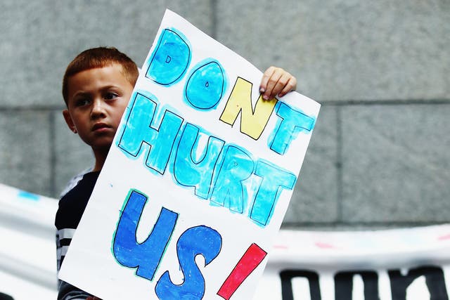 <p>A young boy holds up a sign during a march down Queen Street to bring awareness to child abuse and family violence on 22 May 2016 in Auckland, New Zealand</p>