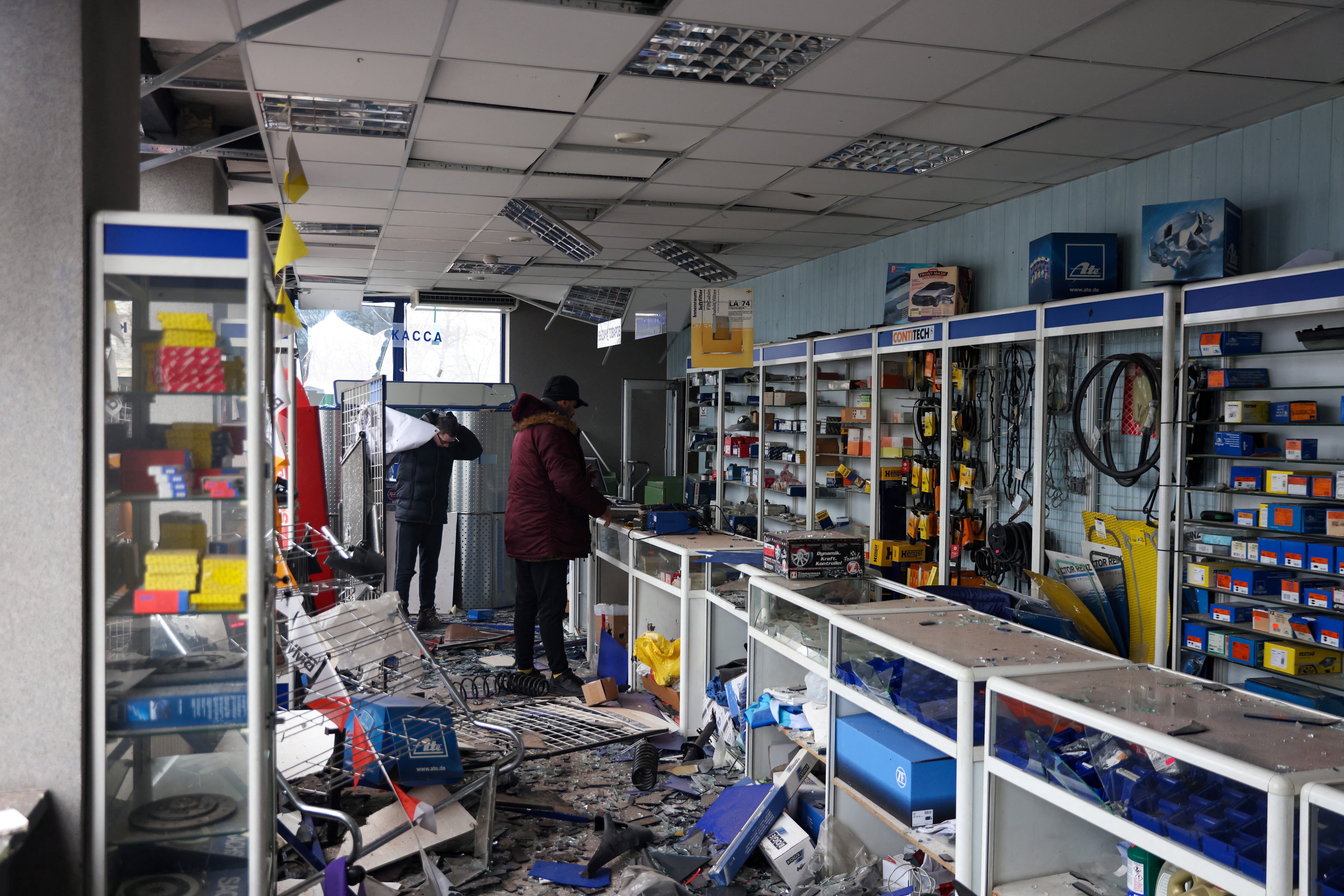 Owners of a Kyiv shop inspect the damage