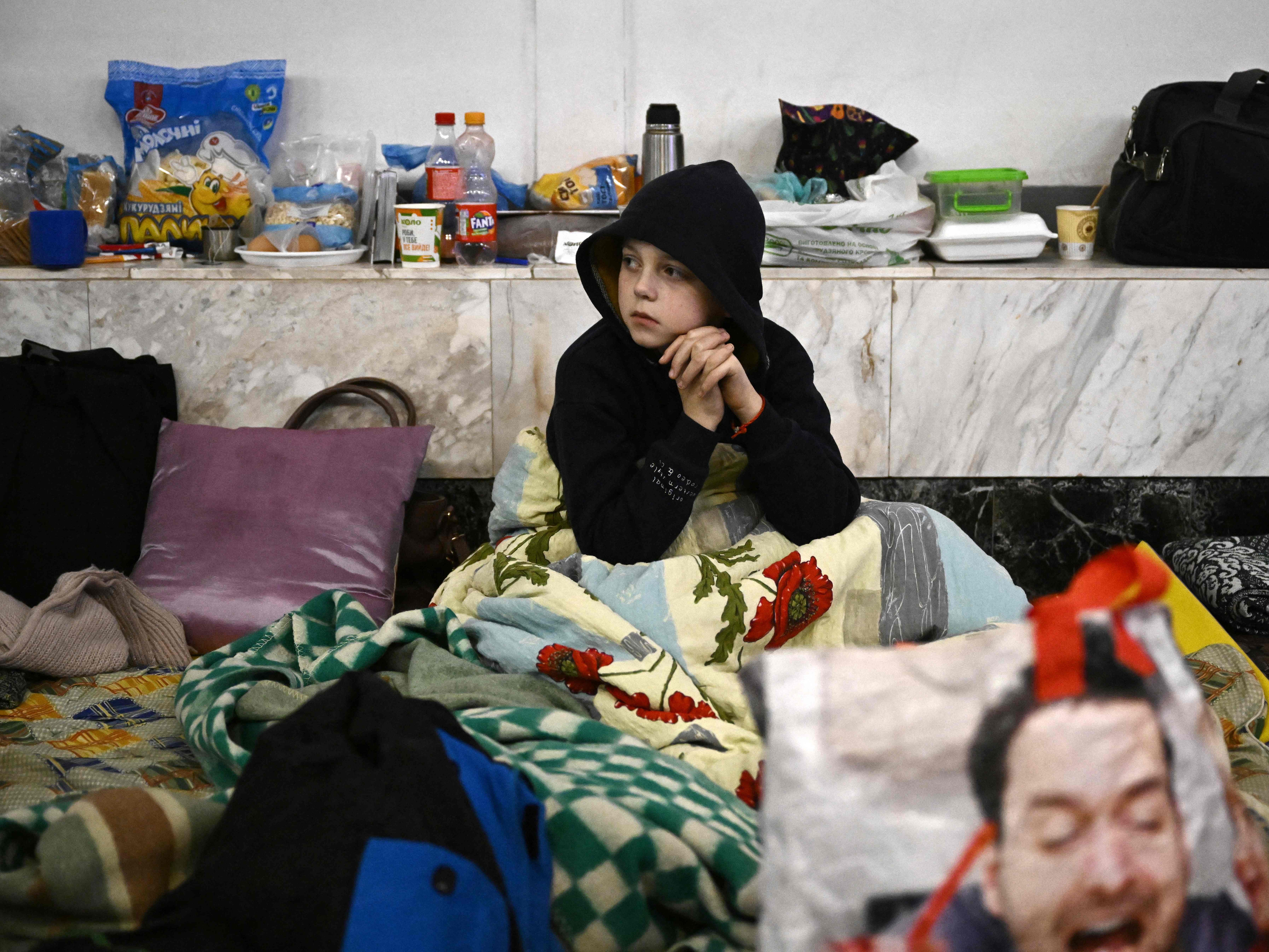 A boy sits at an underground metro station used as bomb shelter in Kyiv