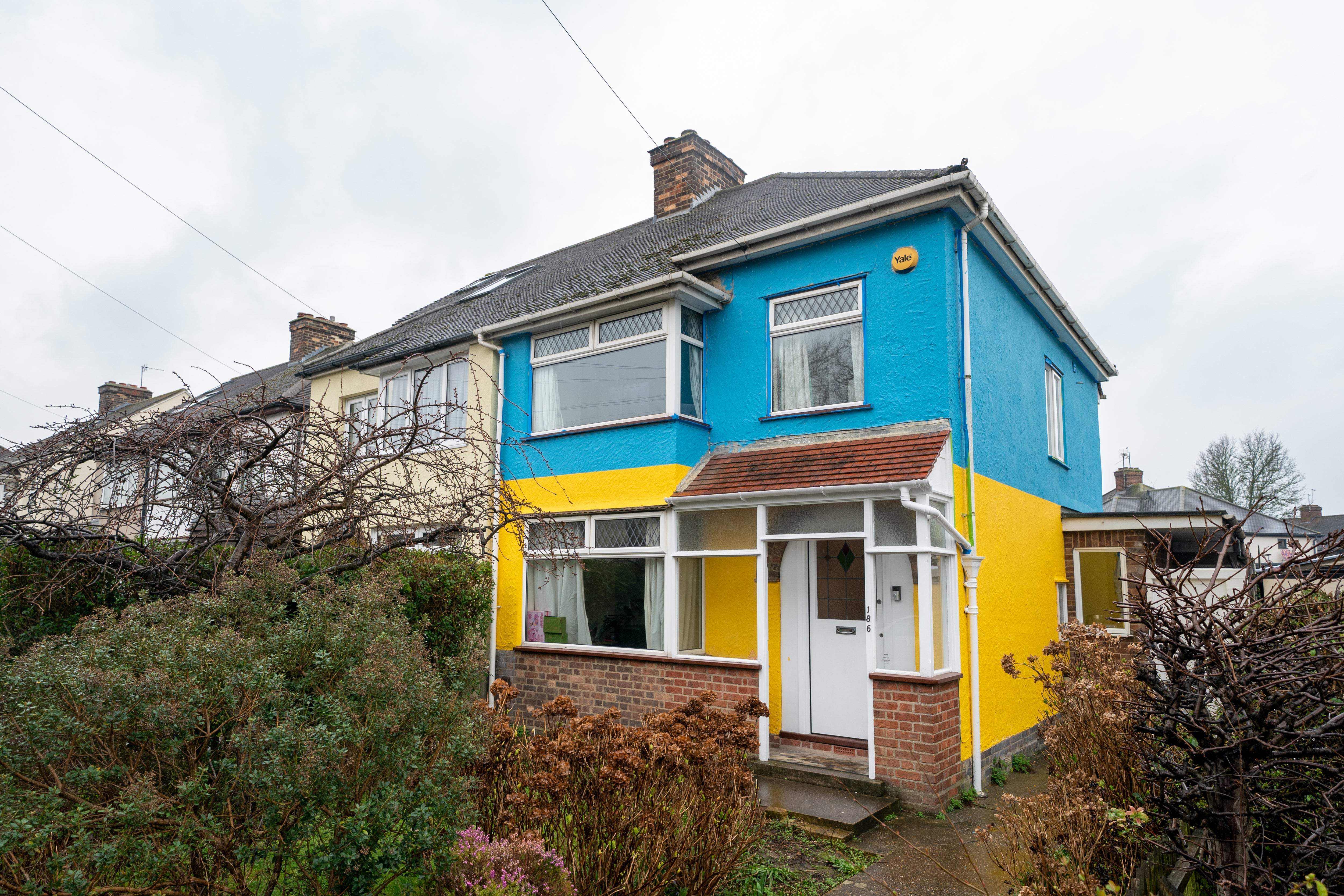 The Platings used two five-litre tubs of paint, one yellow and one blue, costing £76 in total, to decorate the outside of their Cambridge home (Joe Giddens/PA)