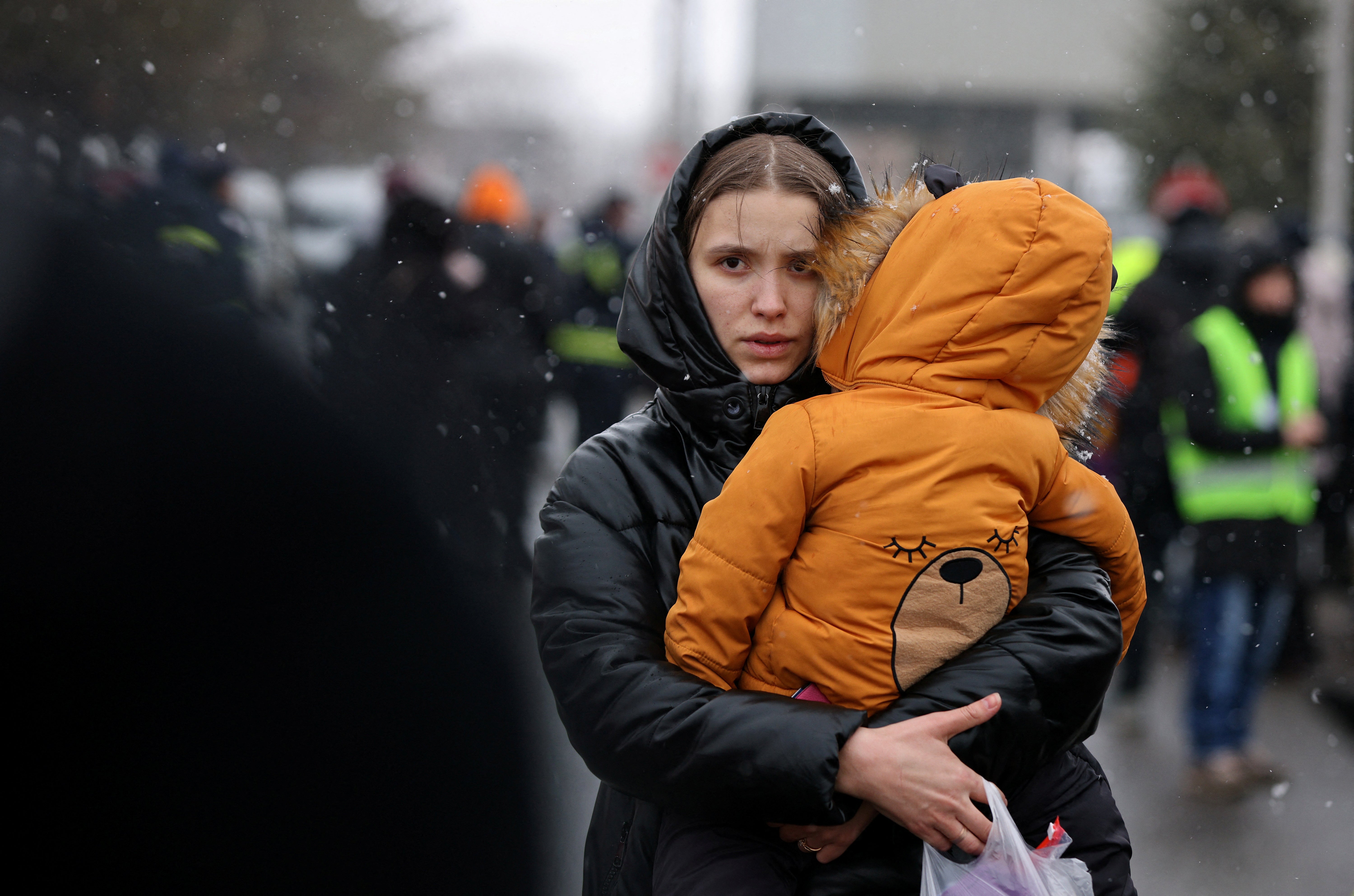 A woman carries a child at the border crossing in Siret, Romania