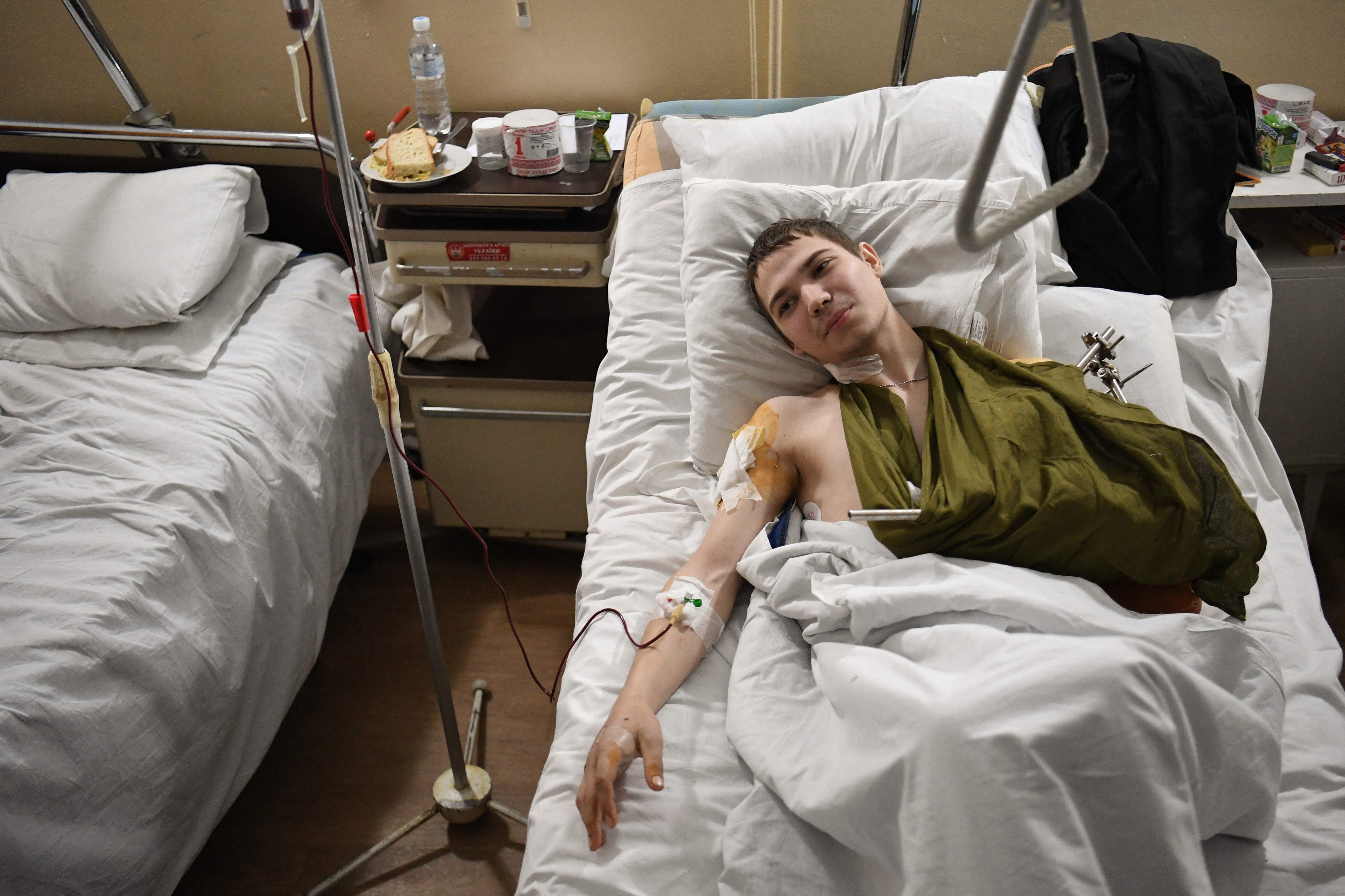 A 19 year old Ukrainian soldier named Yevhen lays in bed in a military hospital in Lviv