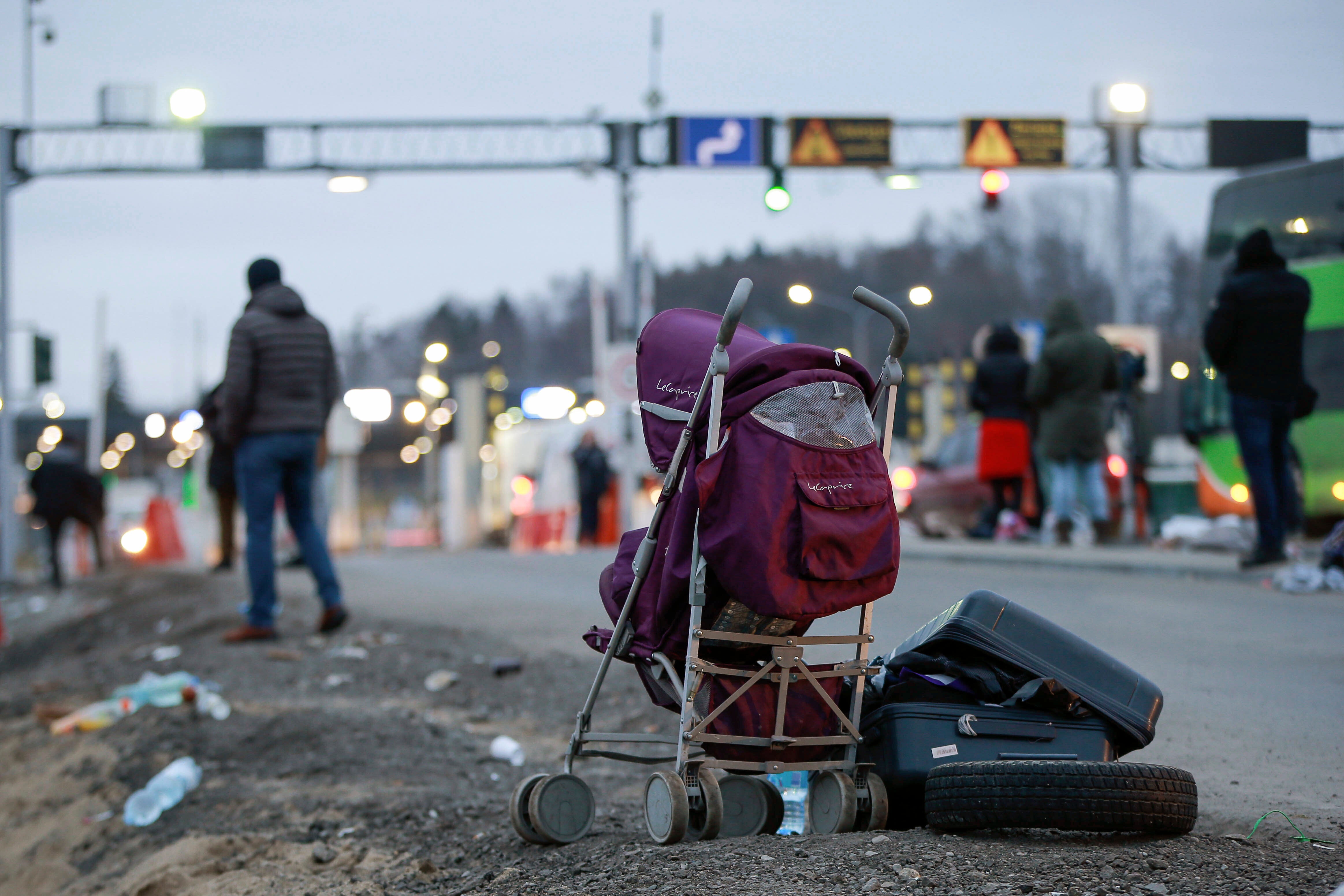 A deserted suitcase and buggy are left beside the road at a border crossing in Medyka, Poland