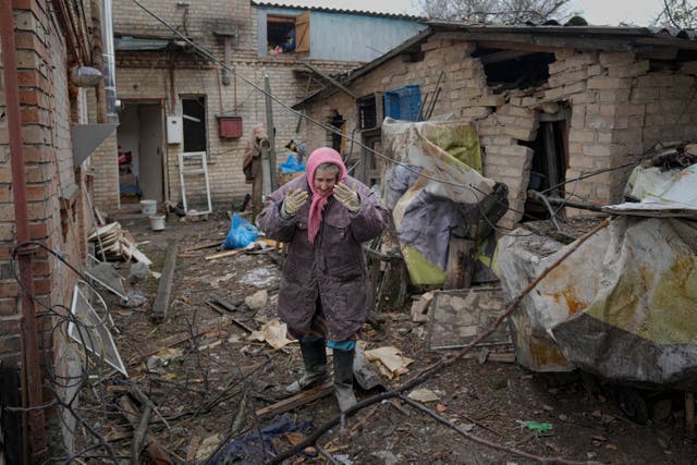 A woman is overwhelmed by emotion in the backyard of a house damaged by a Russian airstrike (Vadim Ghirda/AP)