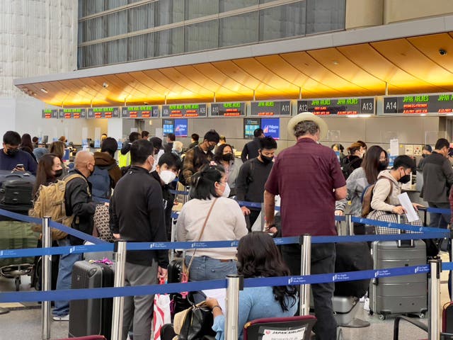 <p>Passengers stand in line at the Japan Airlines ticket counter at Los Angeles International Airport (LAX) in Los Angeles, California, on February 28, 2022. </p>