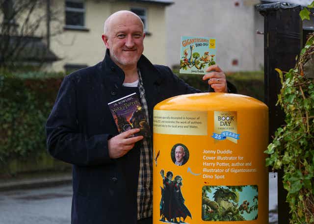 Jonny Duddle standing by the postbox in Nannerch, Flintshire, Wales decorated for World Book Day 2022 (Royal Mail/PA)
