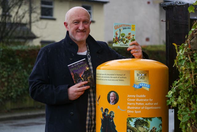 Jonny Duddle standing by the postbox in Nannerch, Flintshire, Wales decorated for World Book Day 2022 (Royal Mail/PA)