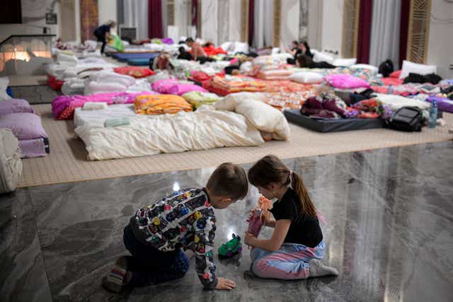 Children who fled the conflict from neighboring Ukraine play on the floor of an event hall in a hotel offering shelter in Siret, Romania (Andreea Alexandru/AP)