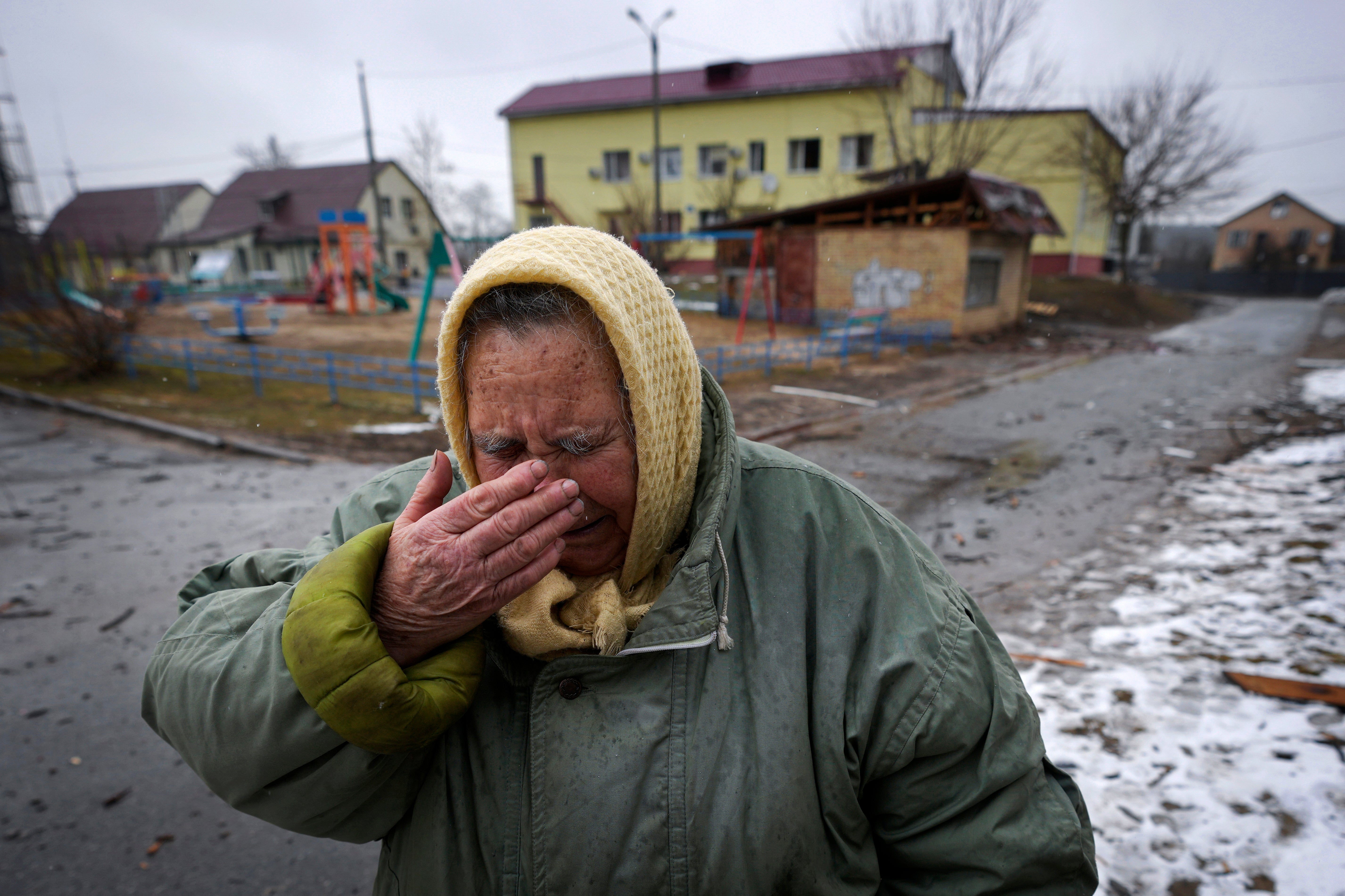 A woman cries outside houses damaged by a Russian airstrike, according to locals, in Gorenka, outside the capital