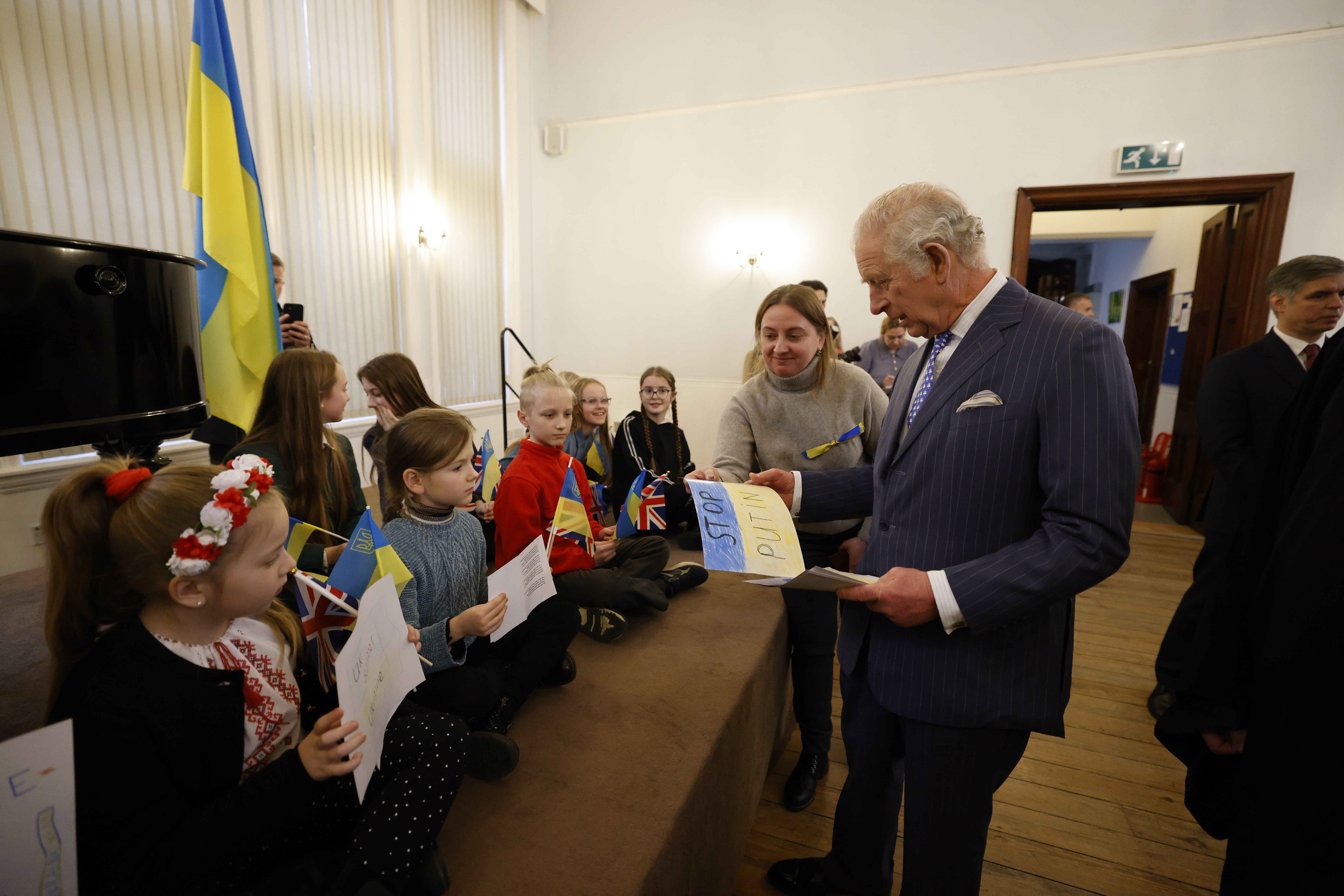 Prince Charles accepts a poster from schoolchildren at the Ukrainian Catholic Cathedral during his visit on Wednesday