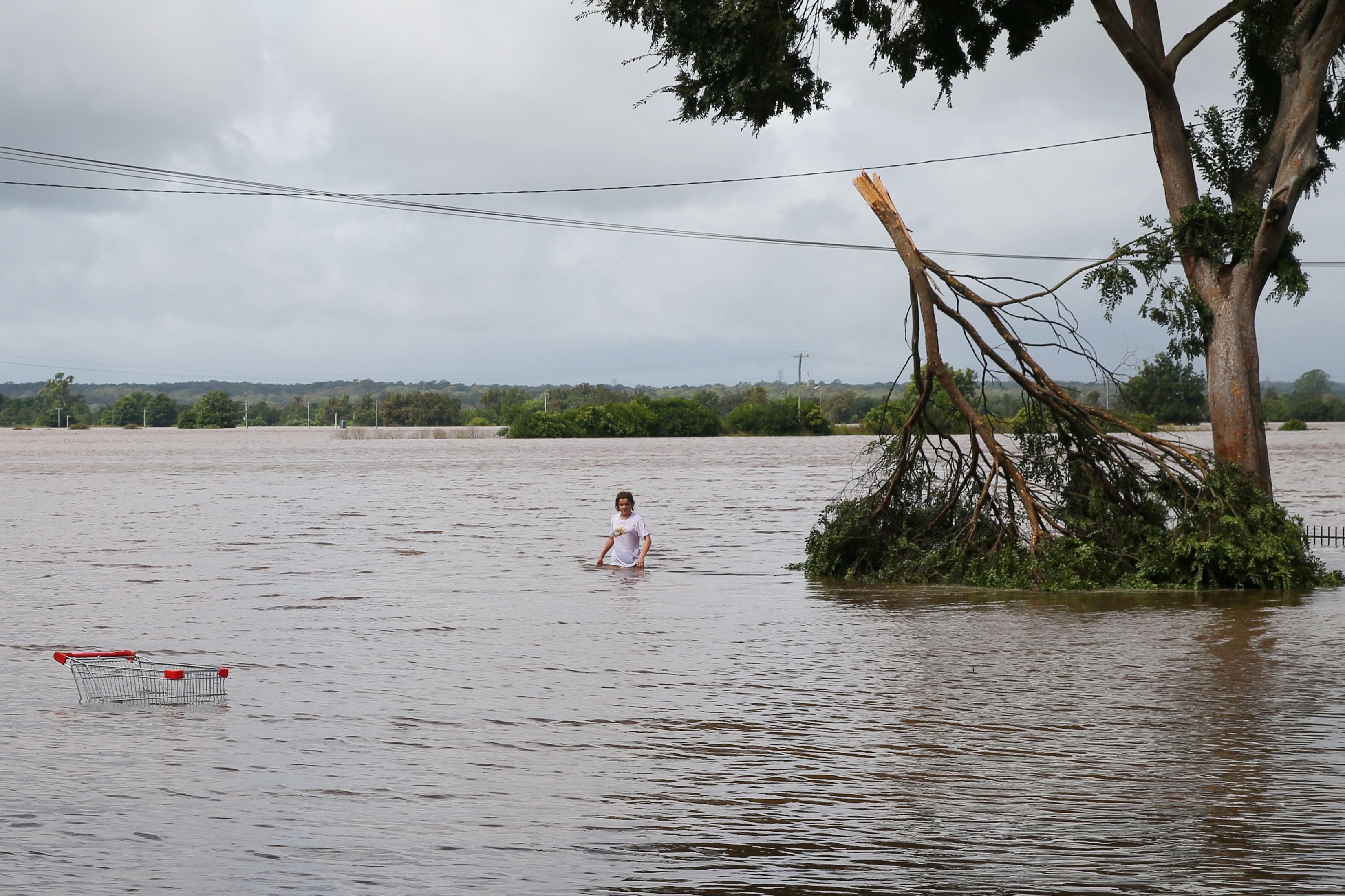 A girl walks through rising floodwaters along the Hawkesbury river