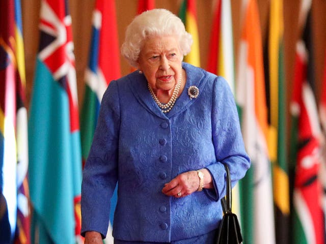 La reina Isabel II pasa junto a las banderas de la Commonwealth en St George's Hall en el Castillo de Windsor el 6 de marzo de 2021