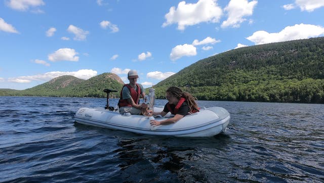 <p>Graduate students Matt Faragher and Vendy Hazukova take a water sample from Jordan Pond</p>