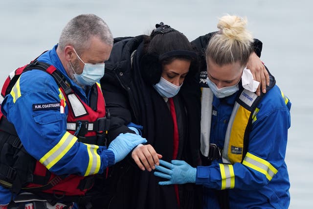 <p>Officials help a woman ashore in Dover, Kent, on Thursday. (Gareth Fuller/PA)</p>