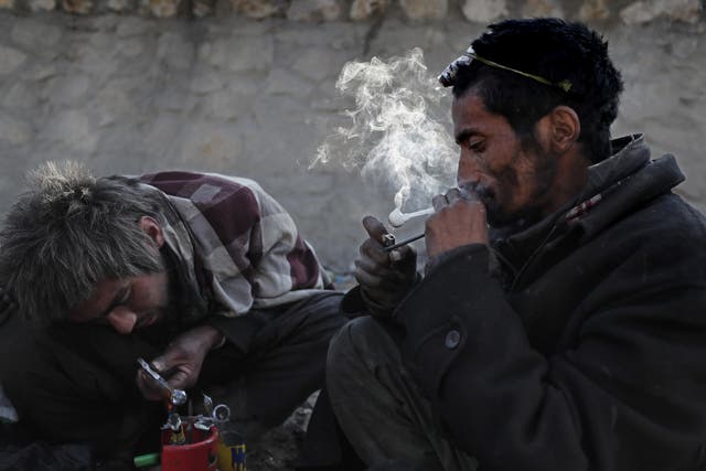 <p>Afghan men addicted to heroin and methamphetamine take drugs in Kabul</p>