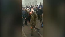 Ukraine citizens jeer Russian soldier demanding their surrender as he holds two grenades