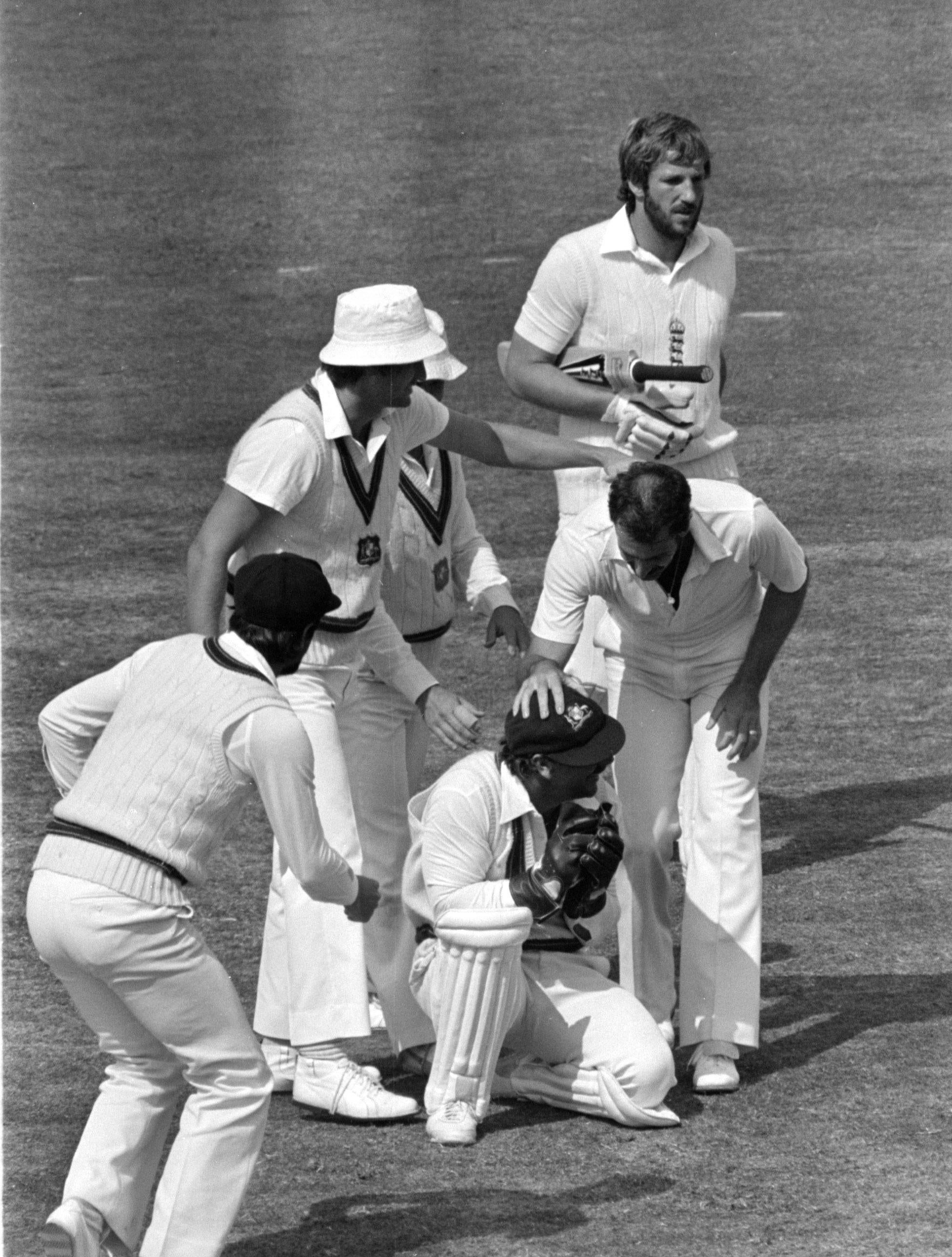 Ian Botham heads off after being caught by Rod Marsh while Dennis Lillee (hatless), the bowler, congratulates Marsh (PA)