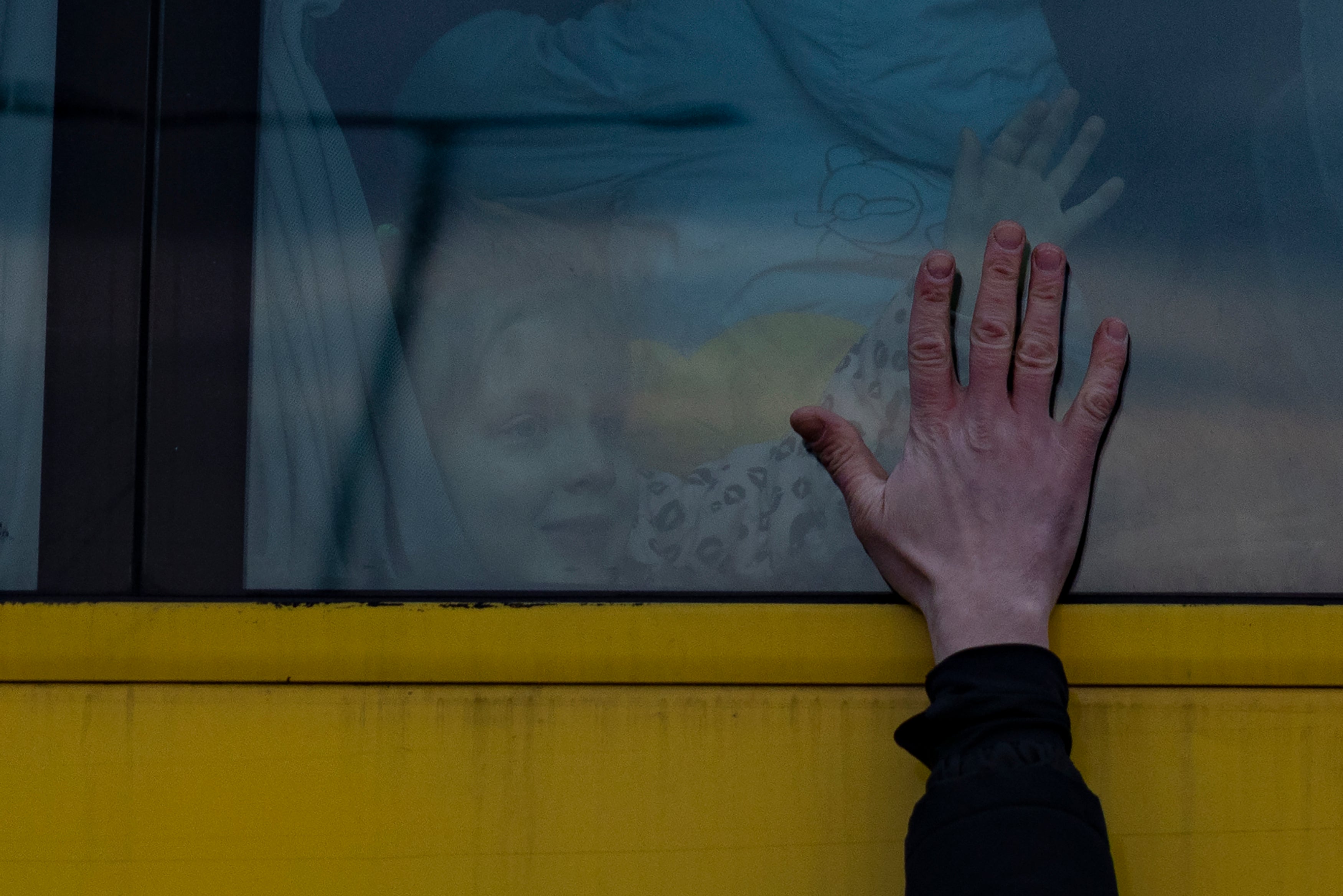 A father says goodbye to his family as they leave Lviv for Poland on a bus