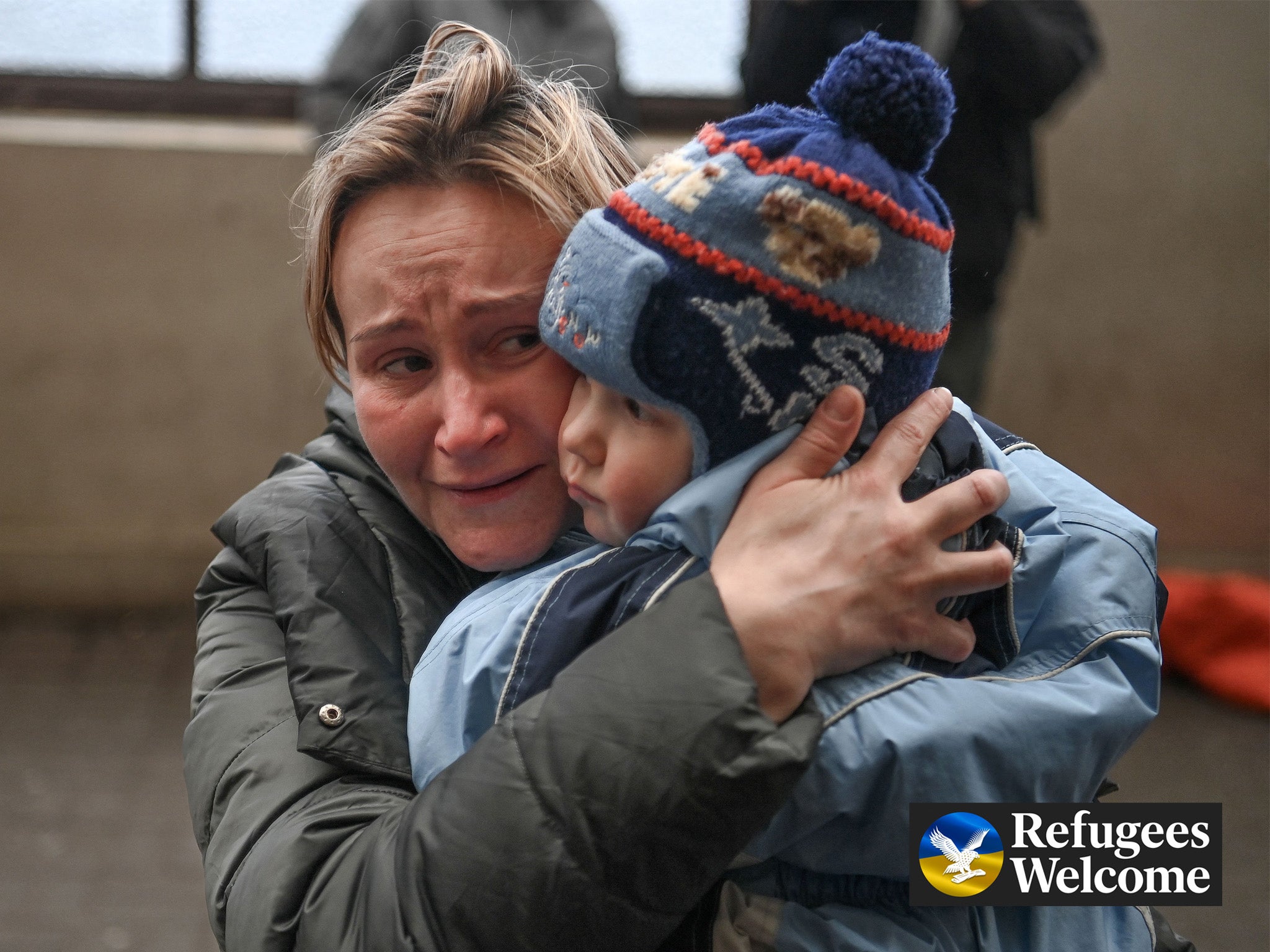 A woman hugs her child as she tries to board a train to Poland at a station in Lviv, west Ukraine