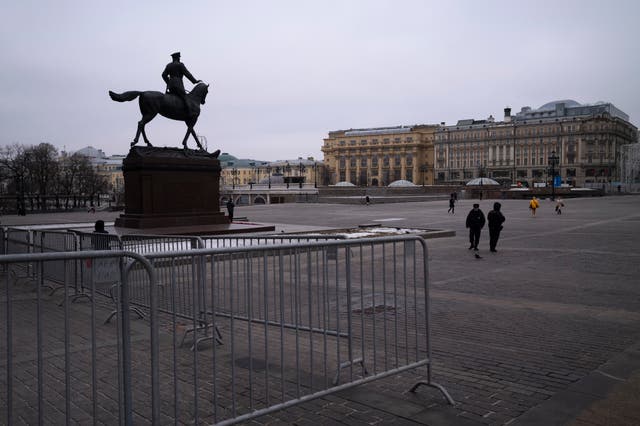 Two police officers patrol Manezhnaya Square with the monument of Soviet Marshal Georgy Zhukov in Moscow, Russia (AP)