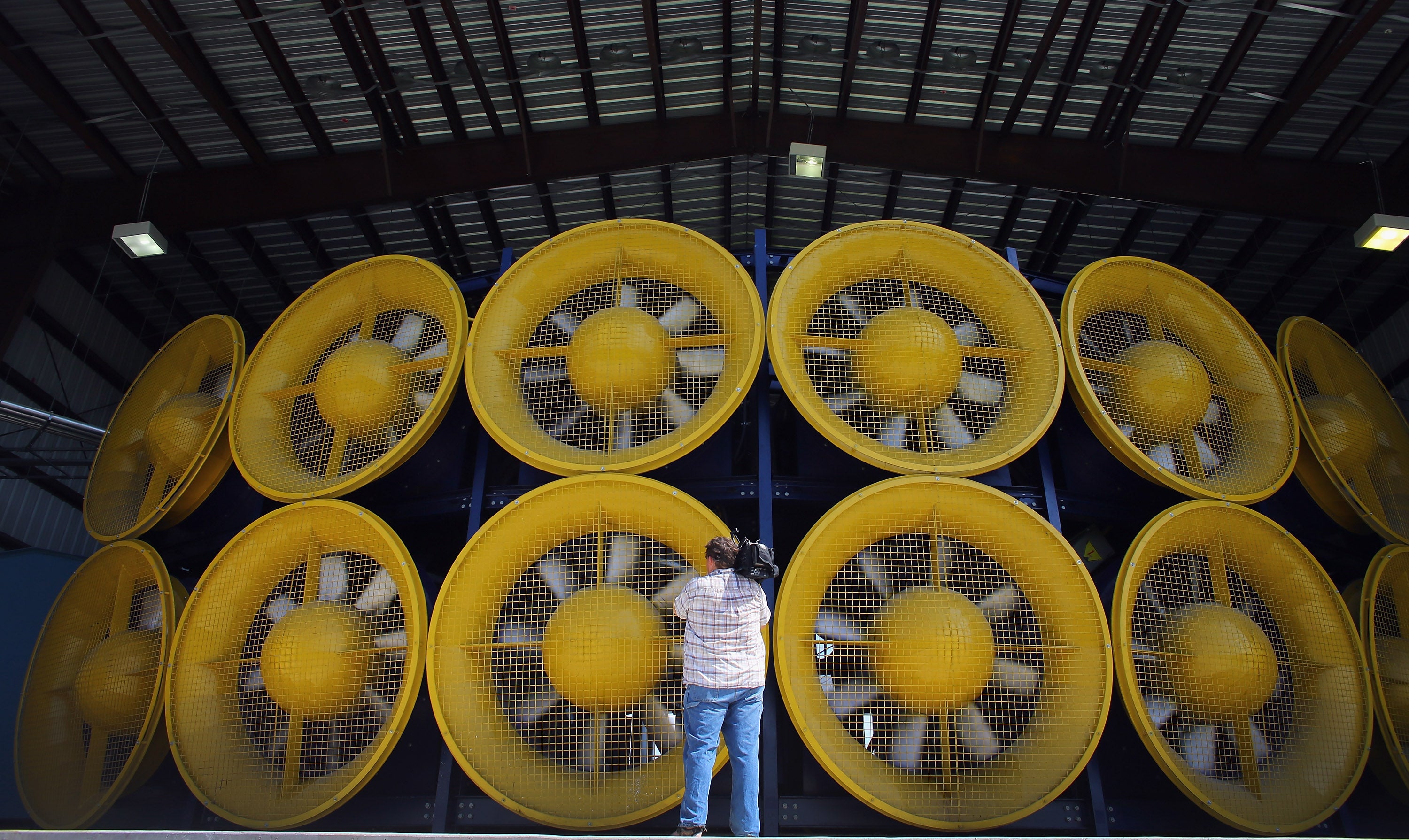 A videographer stands in front of 12 fans, that create what is called a Wall of Wind, at the Florida International University engeneering centre