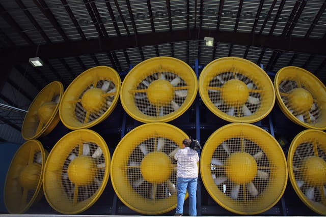 <p>A videographer stands in front of 12 fans, that create what is called a Wall of Wind, at the Florida International University engeneering centre </p>
