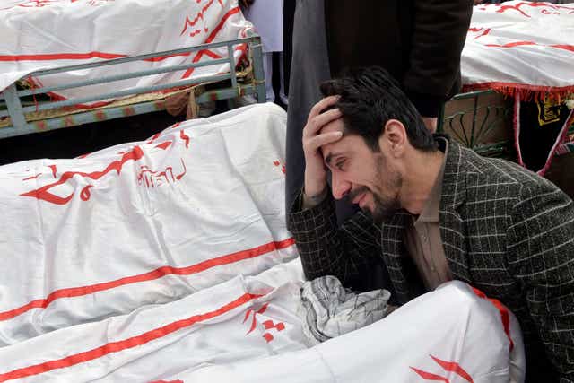 <p>A man mourns next to the body of his relative who died in a bomb blast in Pakistan </p>